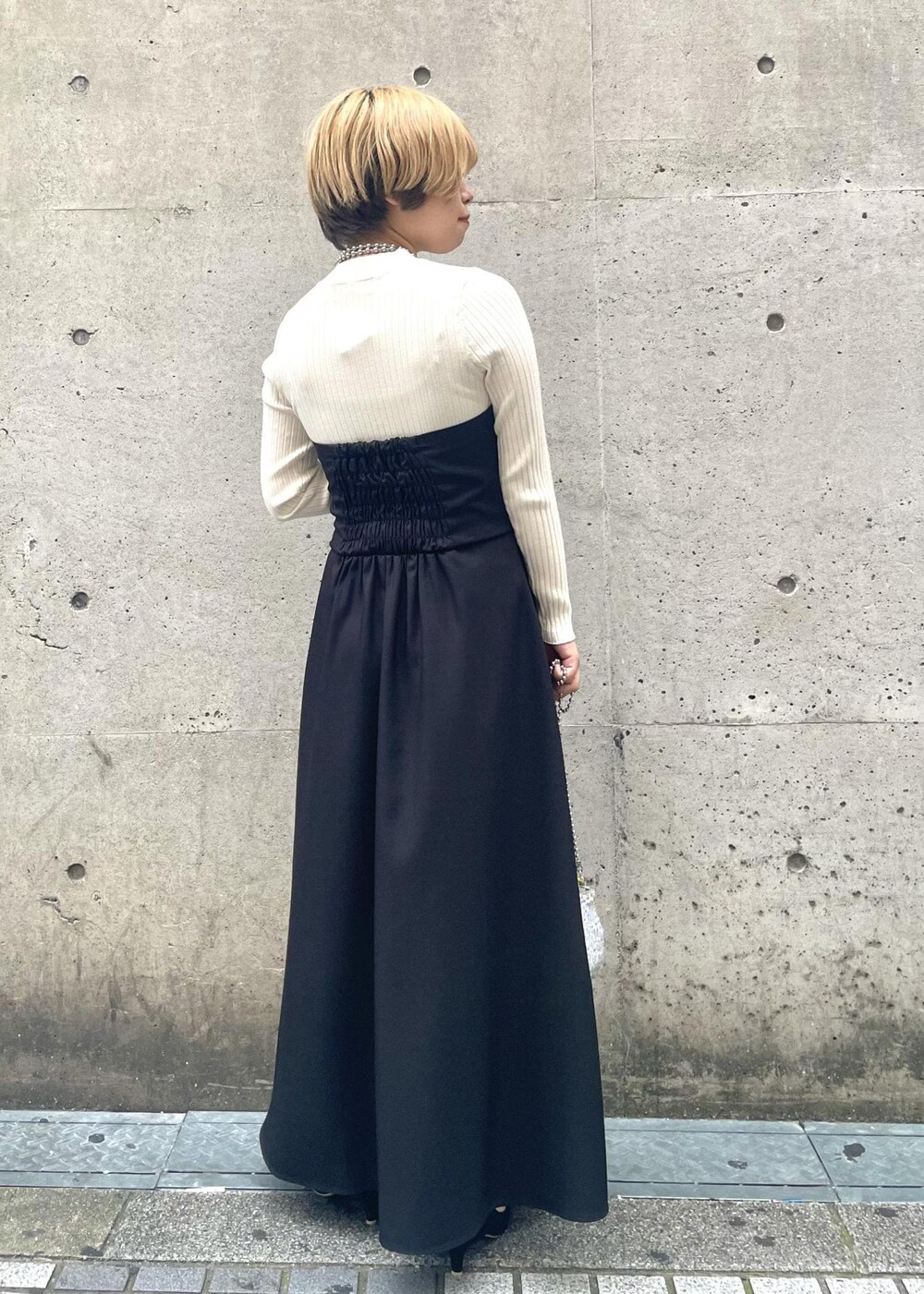 ブラック系のパンプス、ブラック系のワンピース、グレー系のショルダーバッグを着用したレディースの春コーディネートの3枚目の写真