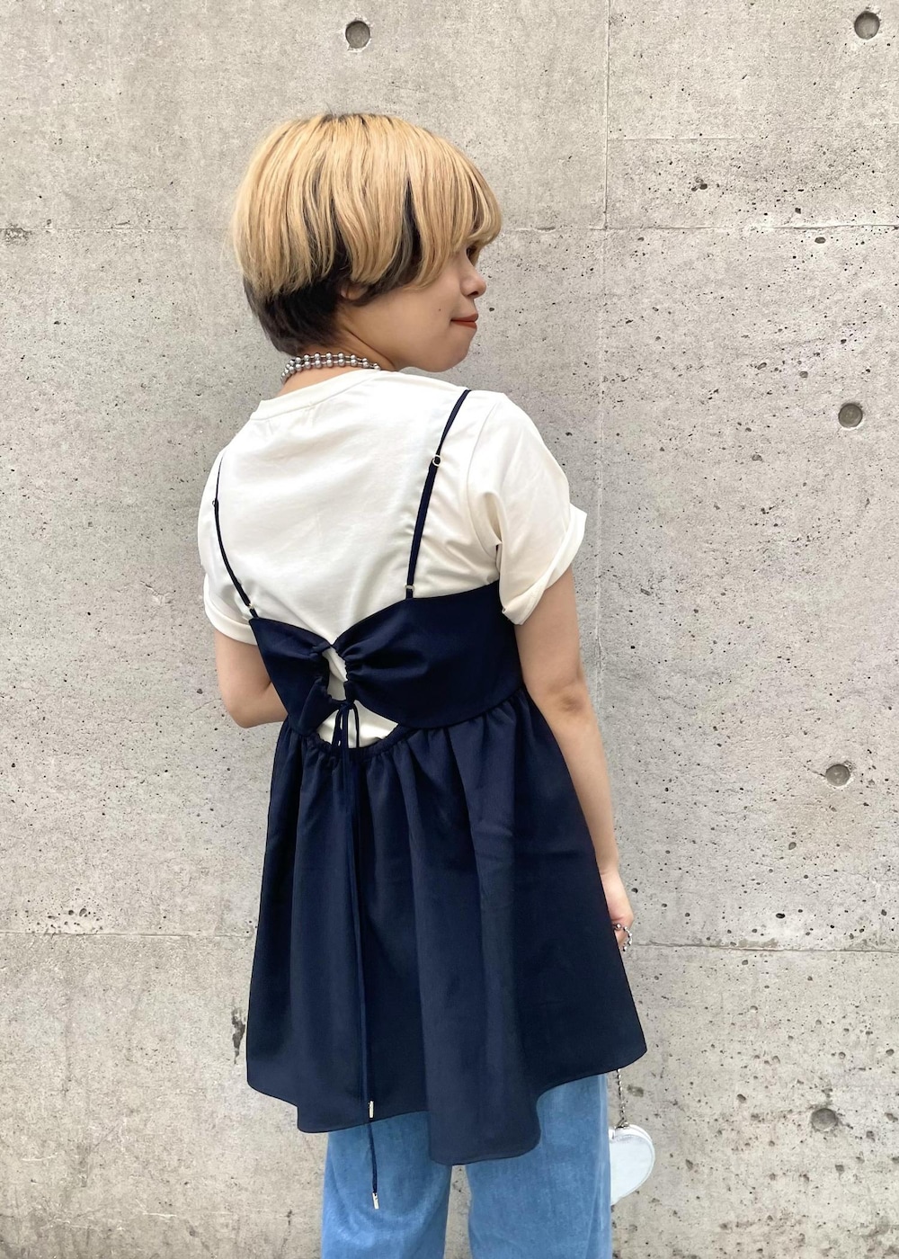 シルバー系のショルダーバッグ、ホワイト系のTシャツ/カットソー、ブルー系のキャミソールを着用したレディースの春コーディネートの5枚目の写真