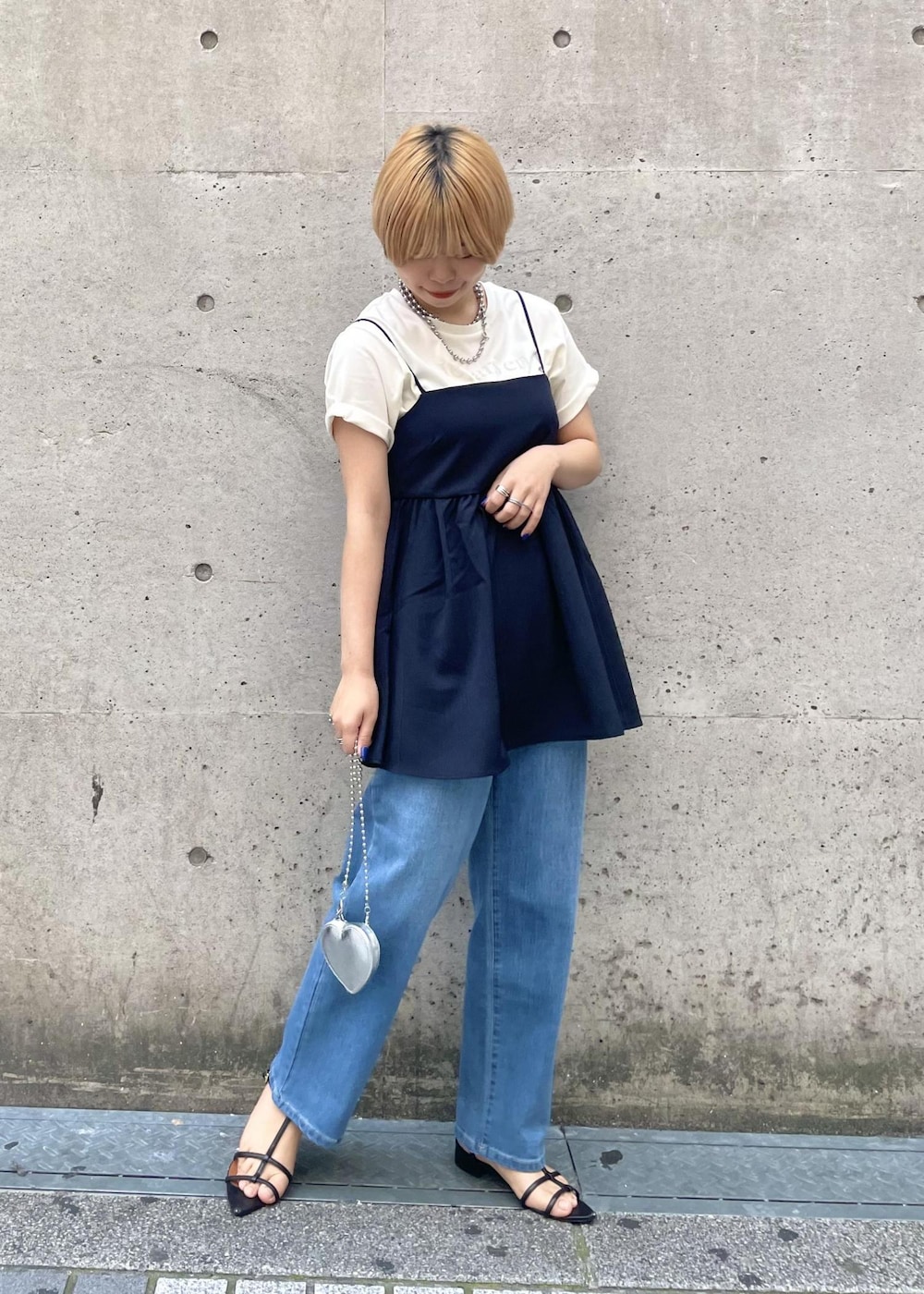 シルバー系のショルダーバッグ、ホワイト系のTシャツ/カットソー、ブルー系のキャミソールを着用したレディースの春コーディネートの2枚目の写真