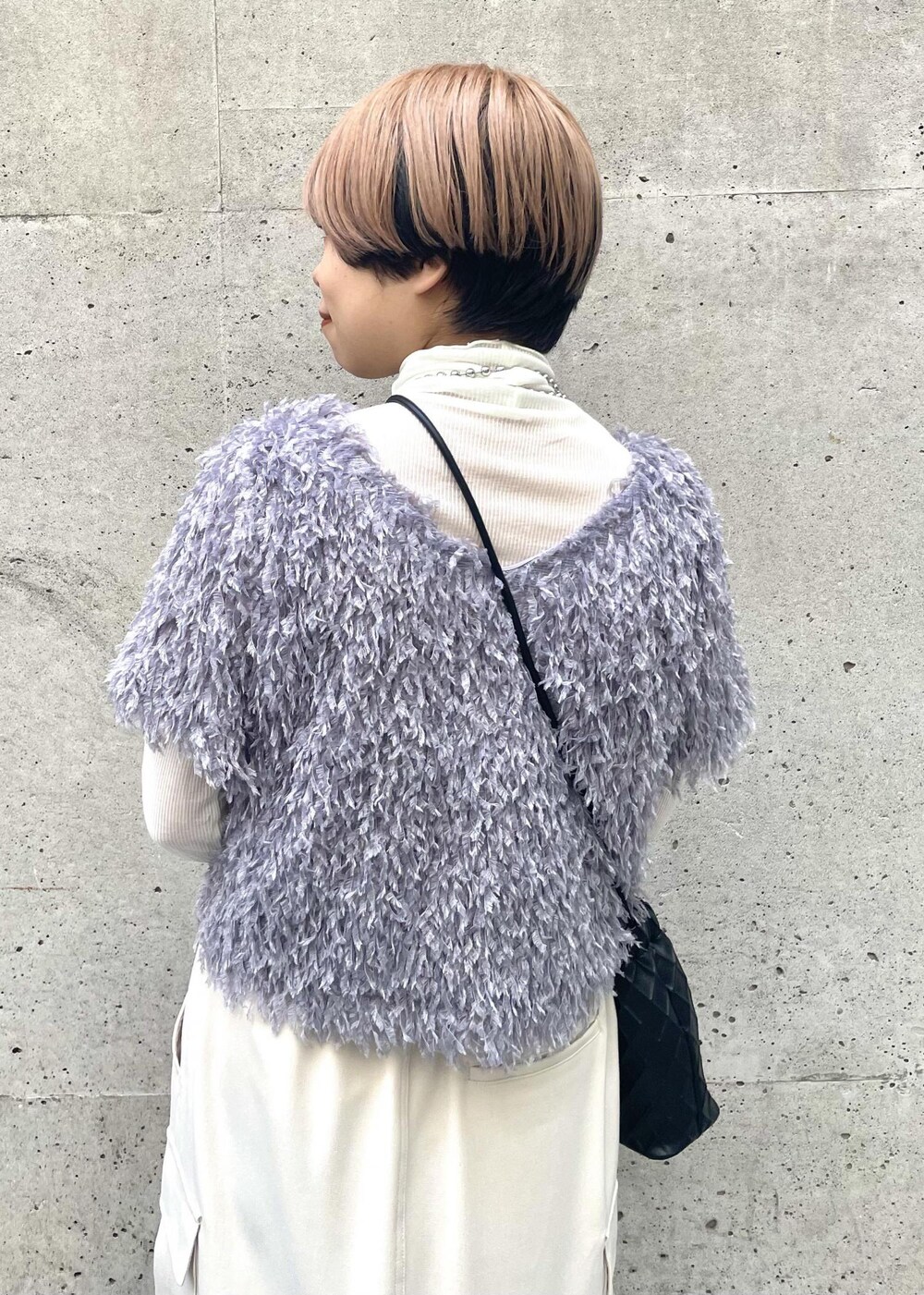 ホワイト系のTシャツ/カットソー、ベージュ系のスカート、ブラック系のスニーカーを着用したレディースの冬コーディネートの5枚目の写真