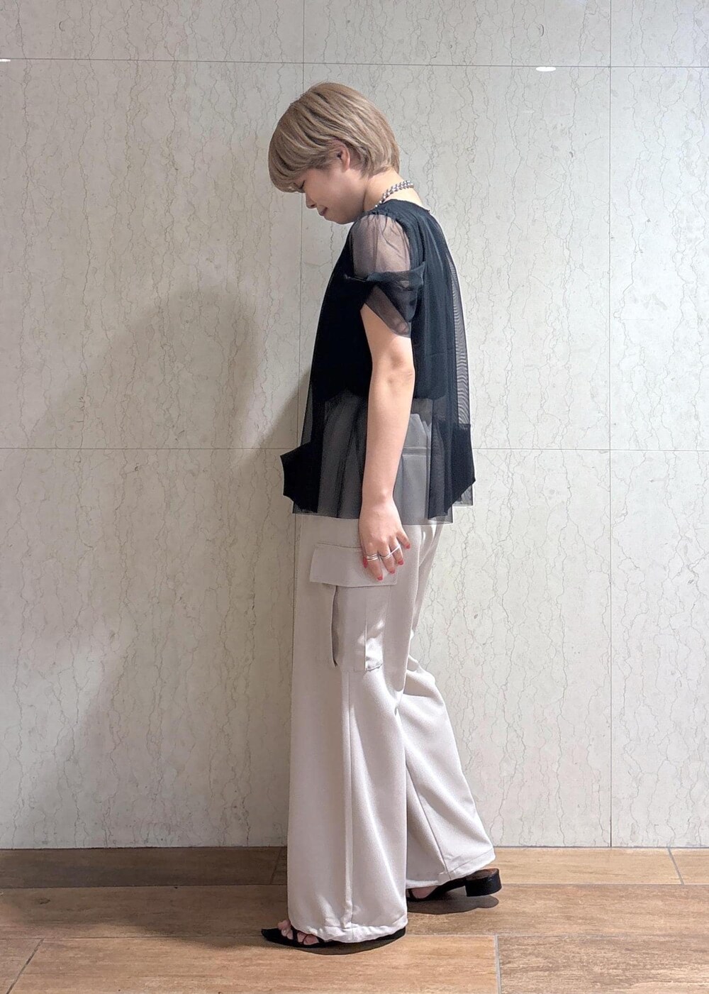 ブラック系のトートバッグ、ベージュ系のカーゴパンツ、ブラック系のTシャツ/カットソーを着用したレディースの春コーディネートの3枚目の写真