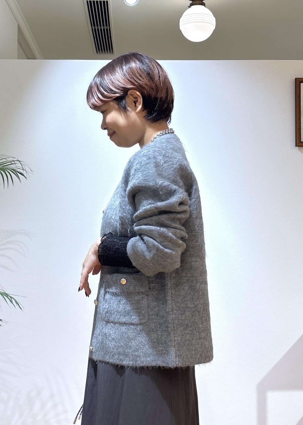 ブラック系のTシャツ/カットソー、グレー系のスカート、グレー系のカーディガン/ボレロを着用したレディースの秋コーディネートの7枚目の写真