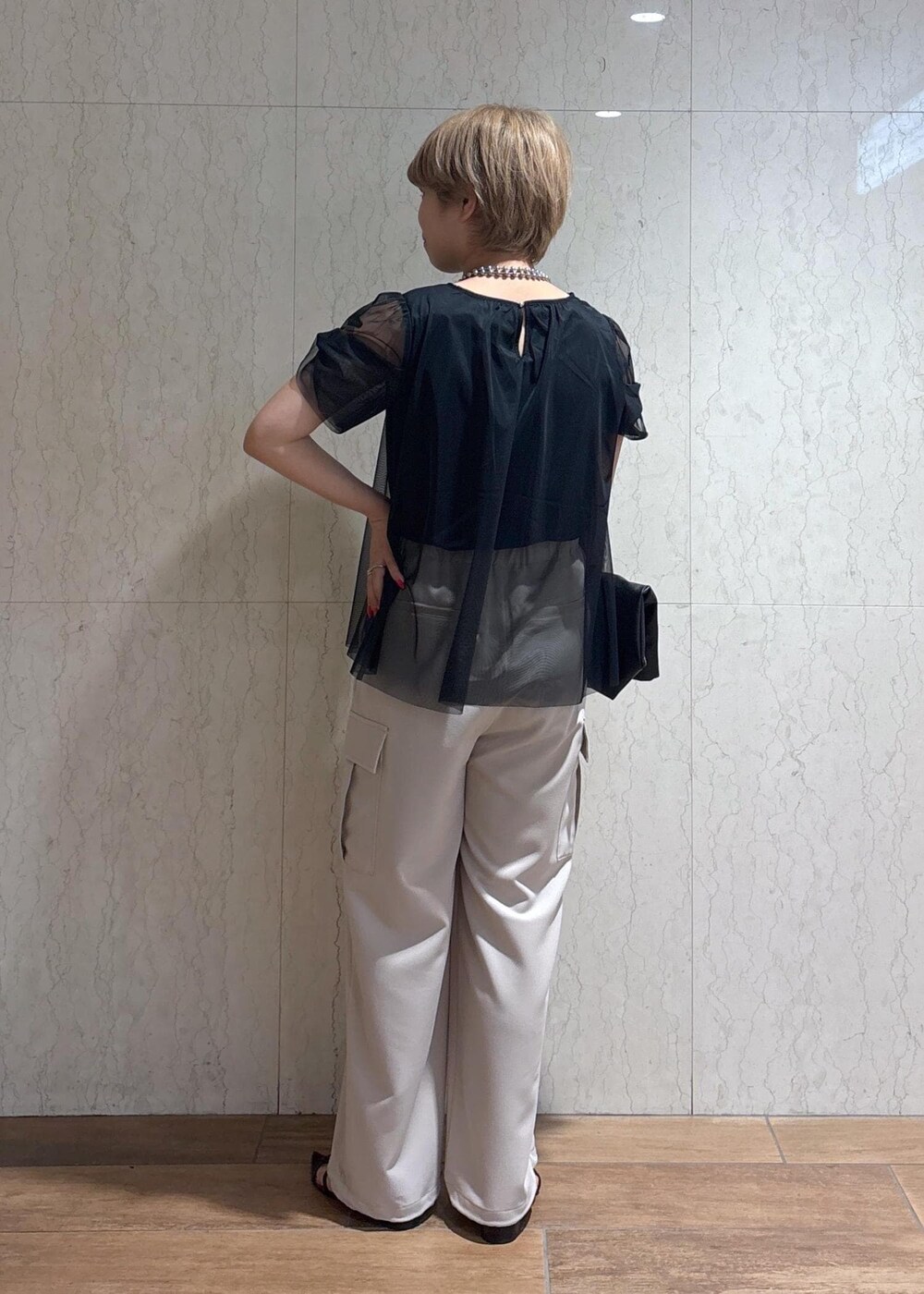 ブラック系のトートバッグ、ベージュ系のカーゴパンツ、ブラック系のTシャツ/カットソーを着用したレディースの春コーディネートの4枚目の写真