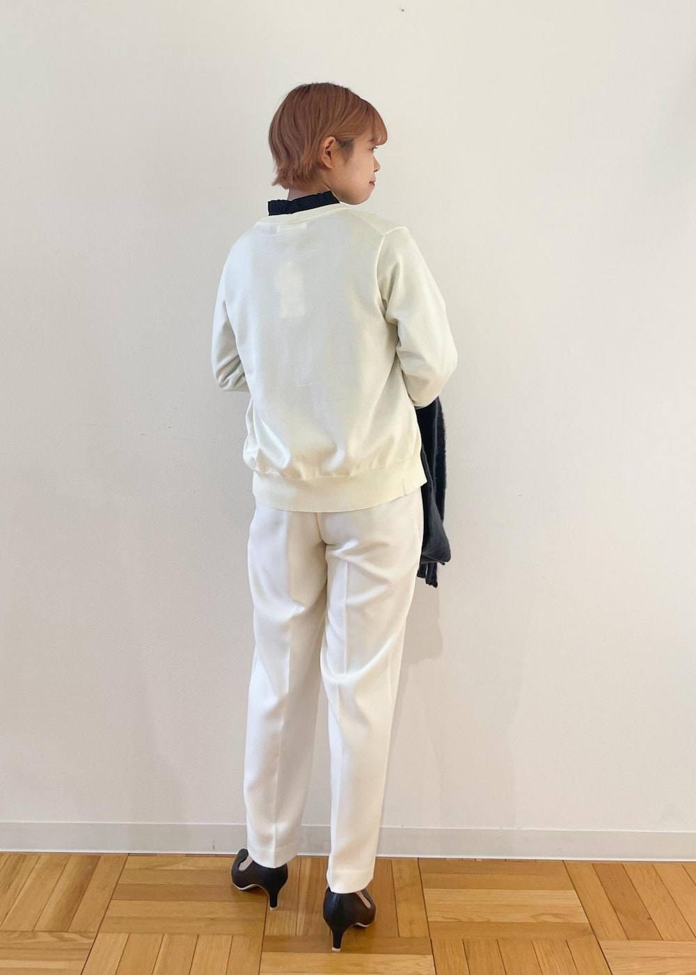 ホワイト系のカーディガン/ボレロ、ブラック系のパンプス、グレー系のシャツ/ブラウスを着用したレディースの冬コーディネートの3枚目の写真