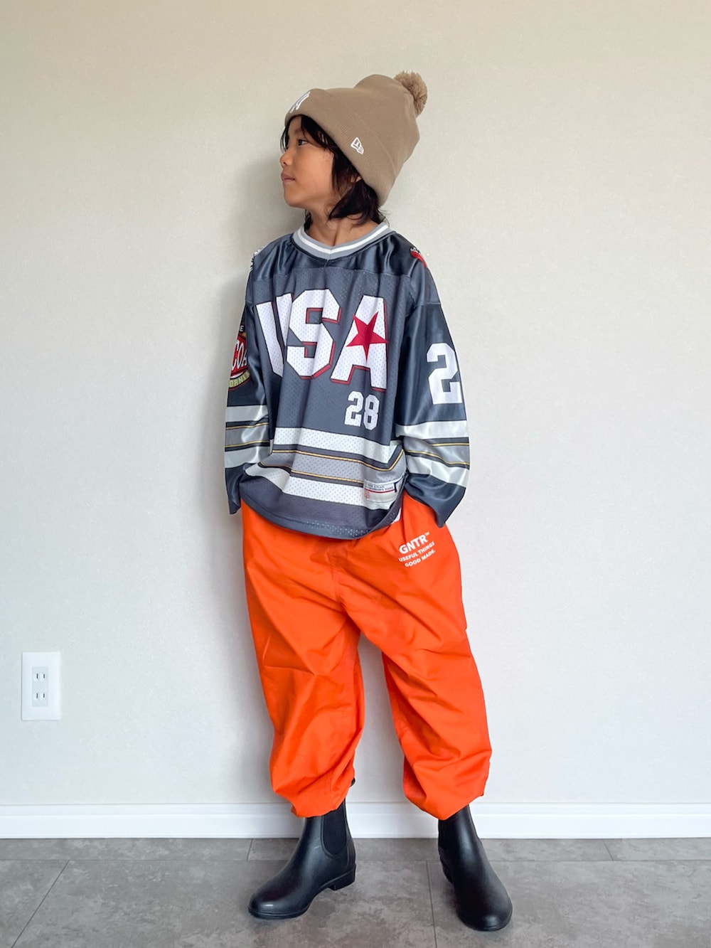 グレー系のTシャツ/カットソー、オレンジ系のその他パンツ、ブラック系のブーツを着用したキッズの秋コーディネートの2枚目の写真