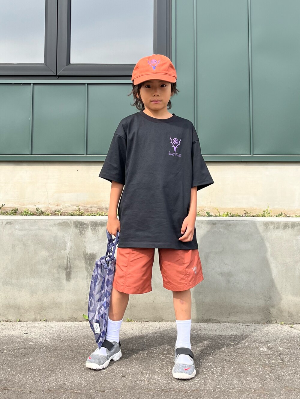 ブラック系のTシャツ/カットソー、オレンジ系のパンツ、パープル系のハンドバッグを着用したキッズの夏コーディネートの4枚目の写真