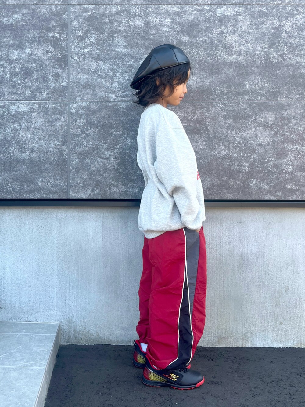 グレー系のスウェット、レッド系のその他パンツ、ブラック系のスニーカーを着用したキッズの秋コーディネートの3枚目の写真