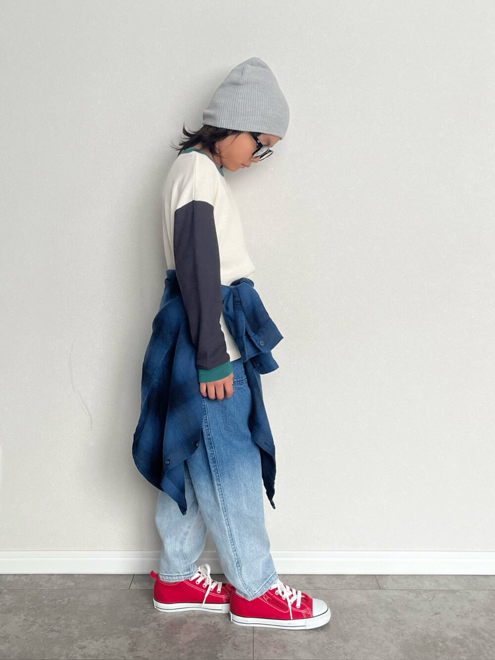 ホワイト系のTシャツ/カットソー、ブルー系のデニムパンツ、レッド系のスニーカーを着用したキッズの冬コーディネートの2枚目の写真
