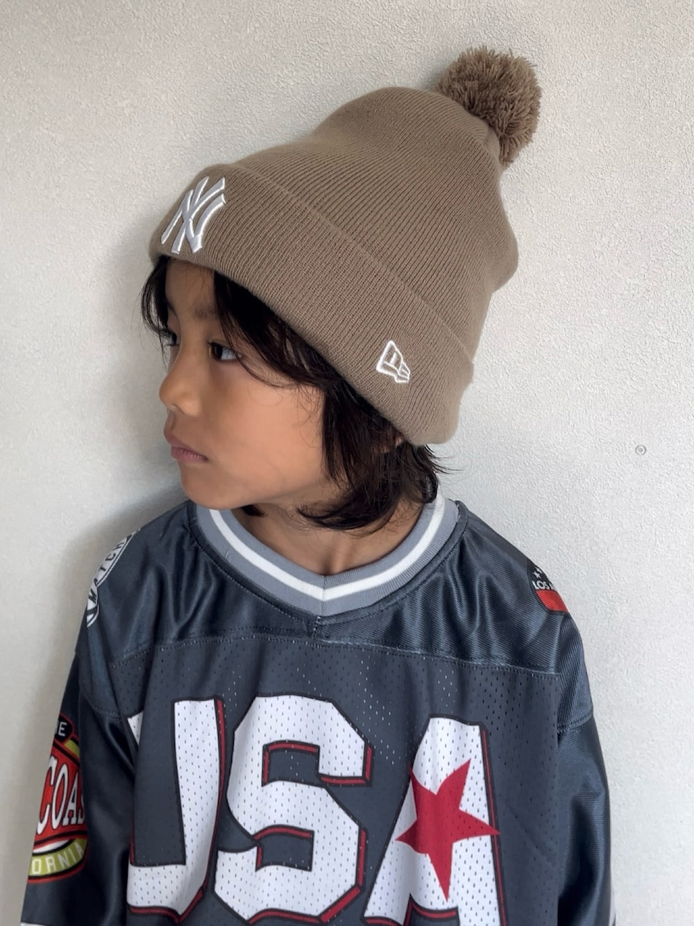 グレー系のTシャツ/カットソー、オレンジ系のその他パンツ、ブラック系のブーツを着用したキッズの秋コーディネートの3枚目の写真