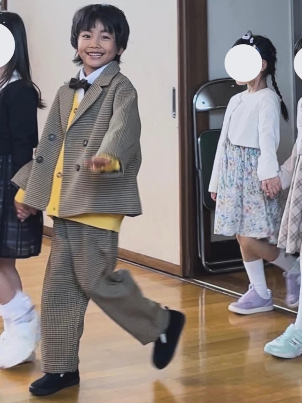 ベージュ系のテーラードジャケット、ホワイト系のシャツ/ブラウス、イエロー系のカーディガン/ボレロを着用したキッズの春コーディネートの2枚目の写真