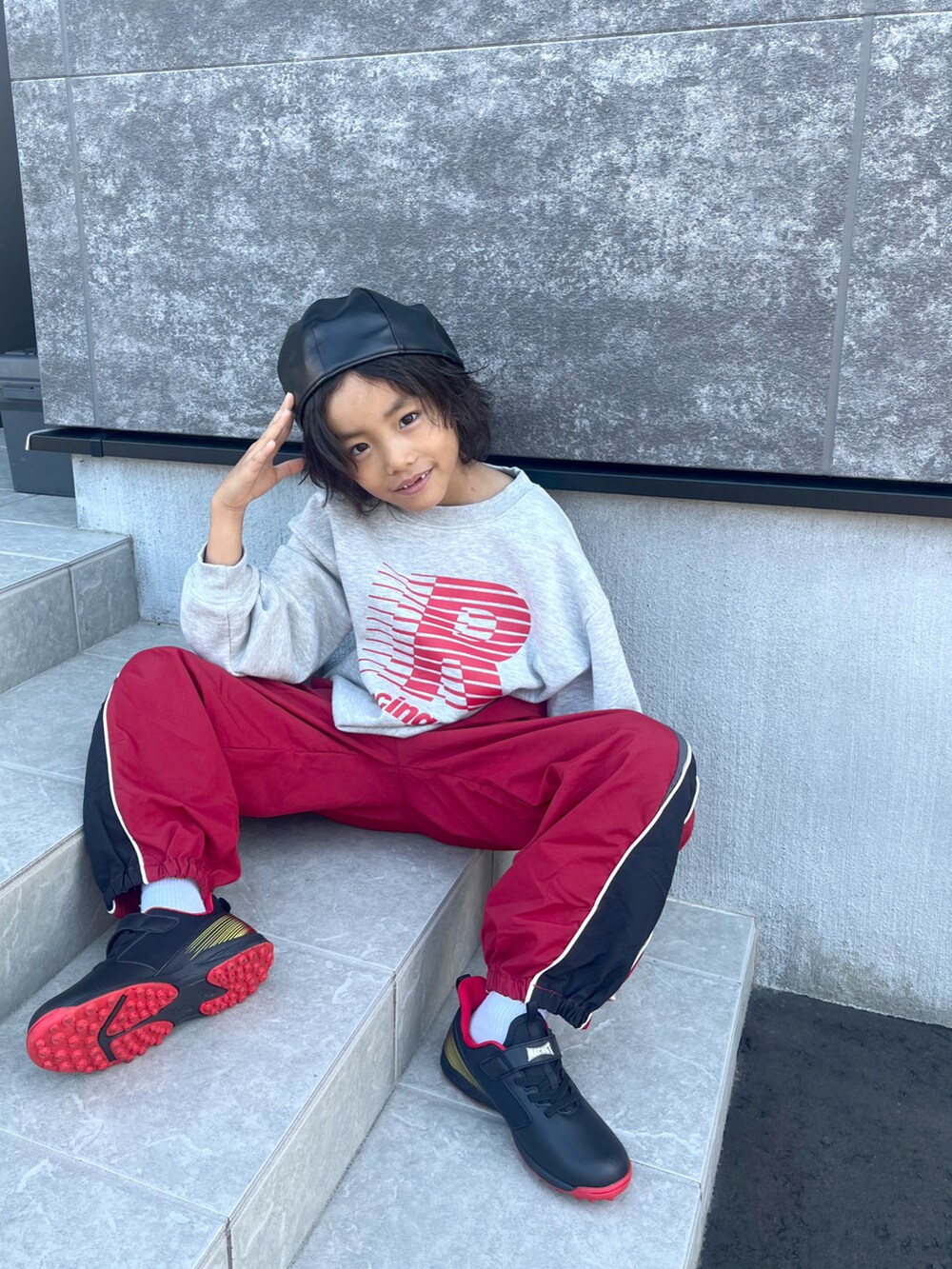グレー系のスウェット、レッド系のその他パンツ、ブラック系のスニーカーを着用したキッズの秋コーディネートの2枚目の写真