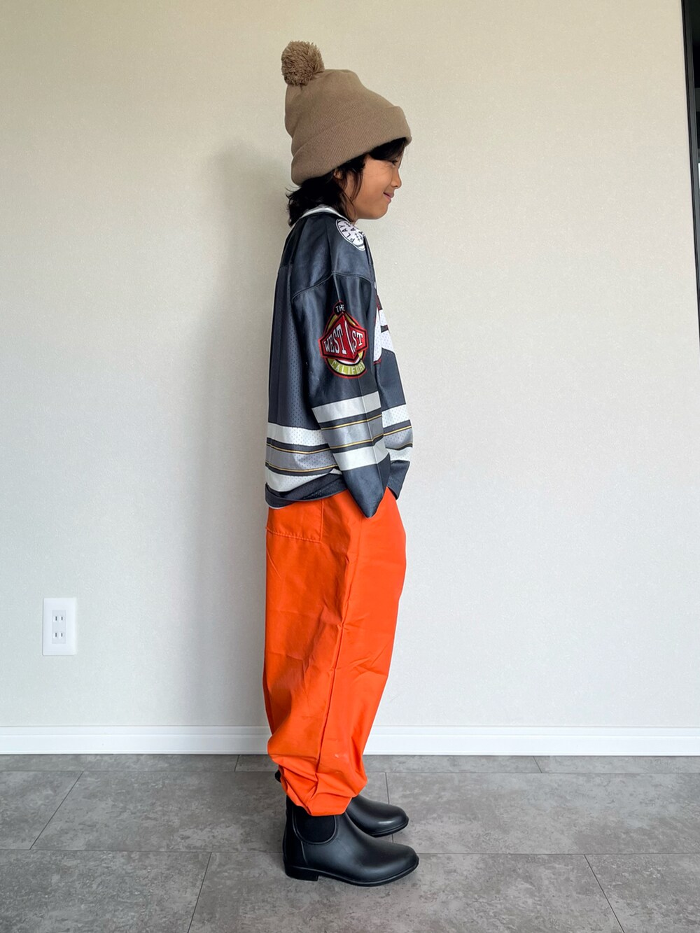 グレー系のTシャツ/カットソー、オレンジ系のその他パンツ、ブラック系のブーツを着用したキッズの秋コーディネートの4枚目の写真
