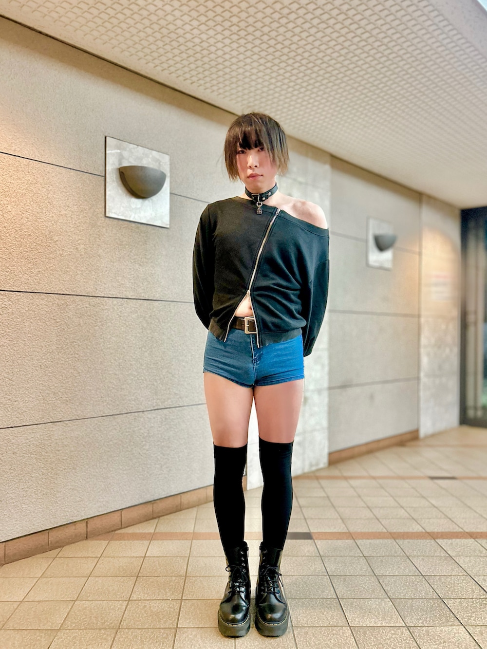 ブラック系のスウェット、ブラック系のブーツ、ブルー系のデニムパンツを着用したメンズの夏コーディネートの3枚目の写真