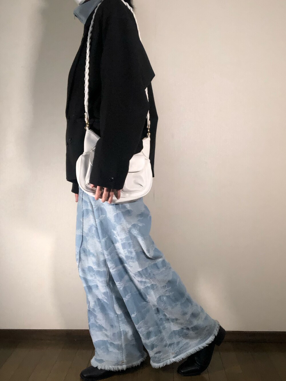 ブラック系のテーラードジャケット、ブルー系のデニムパンツ、ホワイト系のショルダーバッグを着用したメンズの冬コーディネートの2枚目の写真