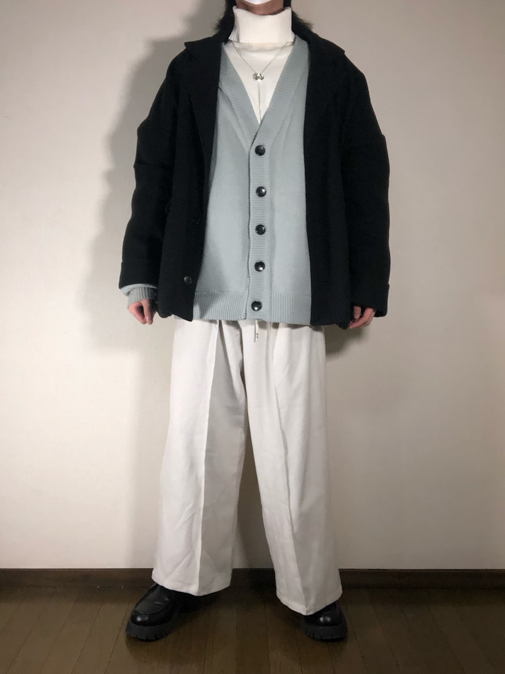 ブラック系のローファー、ベージュ系のスラックス、ブラック系のチェスターコートを着用したメンズの冬コーディネートの2枚目の写真