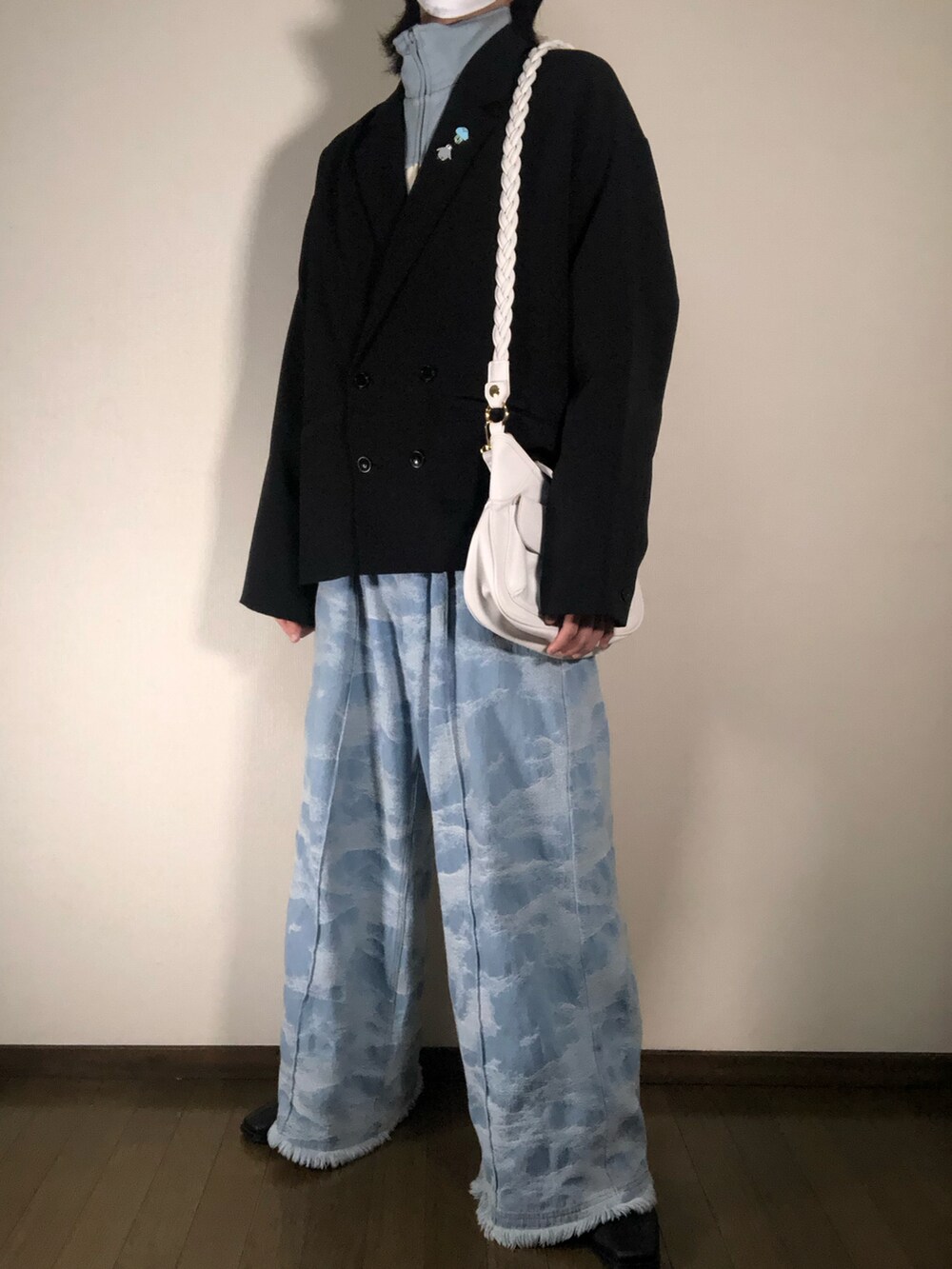 ブラック系のテーラードジャケット、ブルー系のデニムパンツ、ホワイト系のショルダーバッグを着用したメンズの冬コーディネートの3枚目の写真