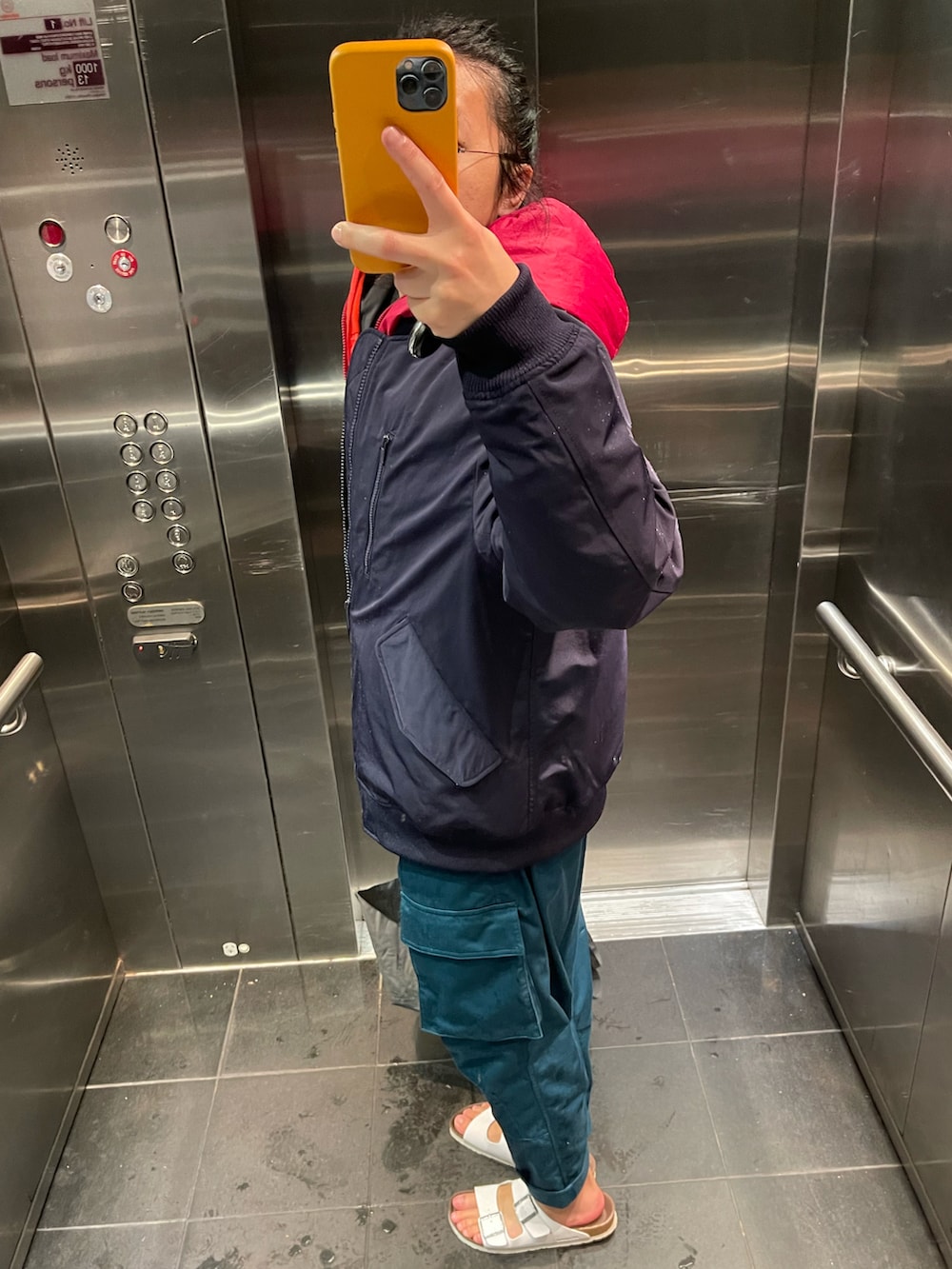 グリーン系のチノパンツ、ブラック系のサンダル、ブルー系のMA-1を着用したメンズの春コーディネートの2枚目の写真