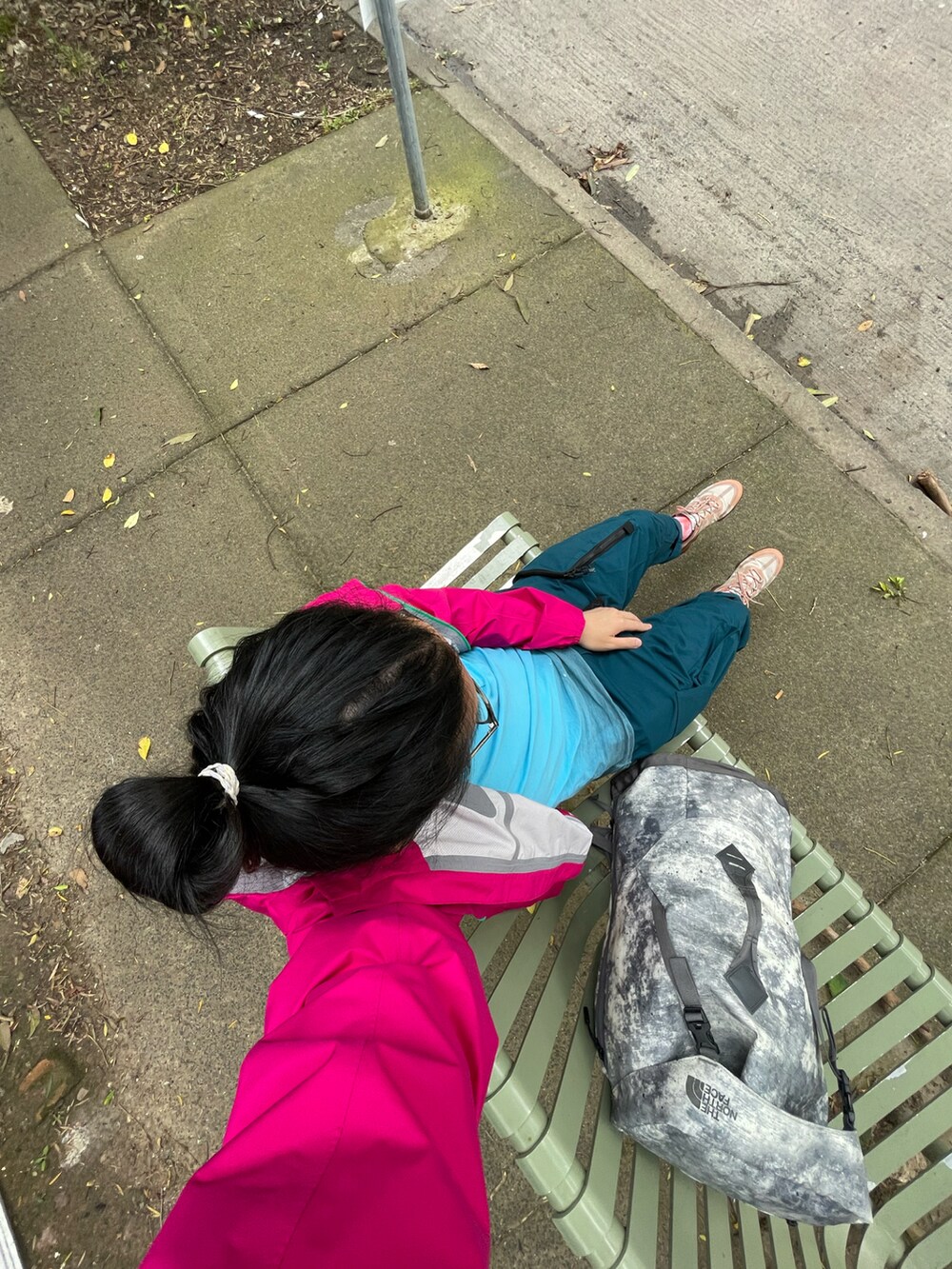 レッド系のマウンテンパーカー、グリーン系のチノパンツ、オレンジ系のスニーカーを着用したメンズの冬コーディネートの2枚目の写真