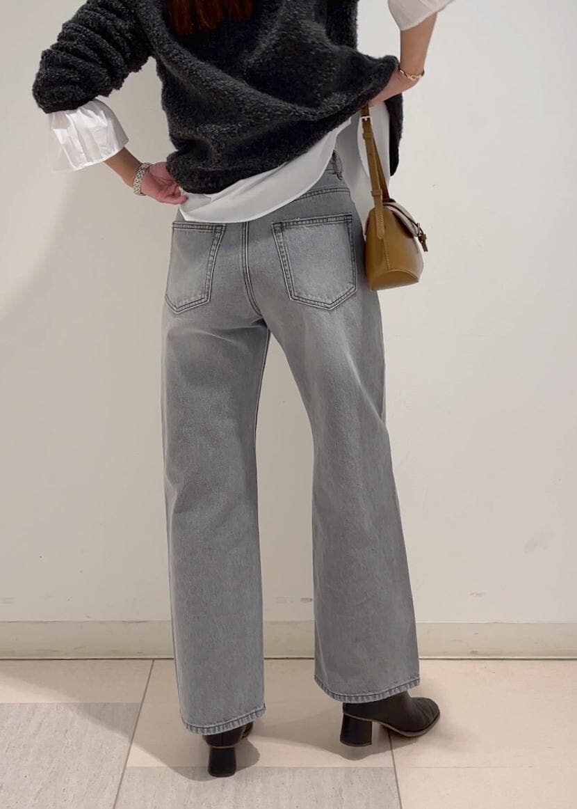 ブラウン系のショルダーバッグ、ブラック系のブーツ、グレー系のブルゾンを着用したレディースの冬コーディネートの4枚目の写真