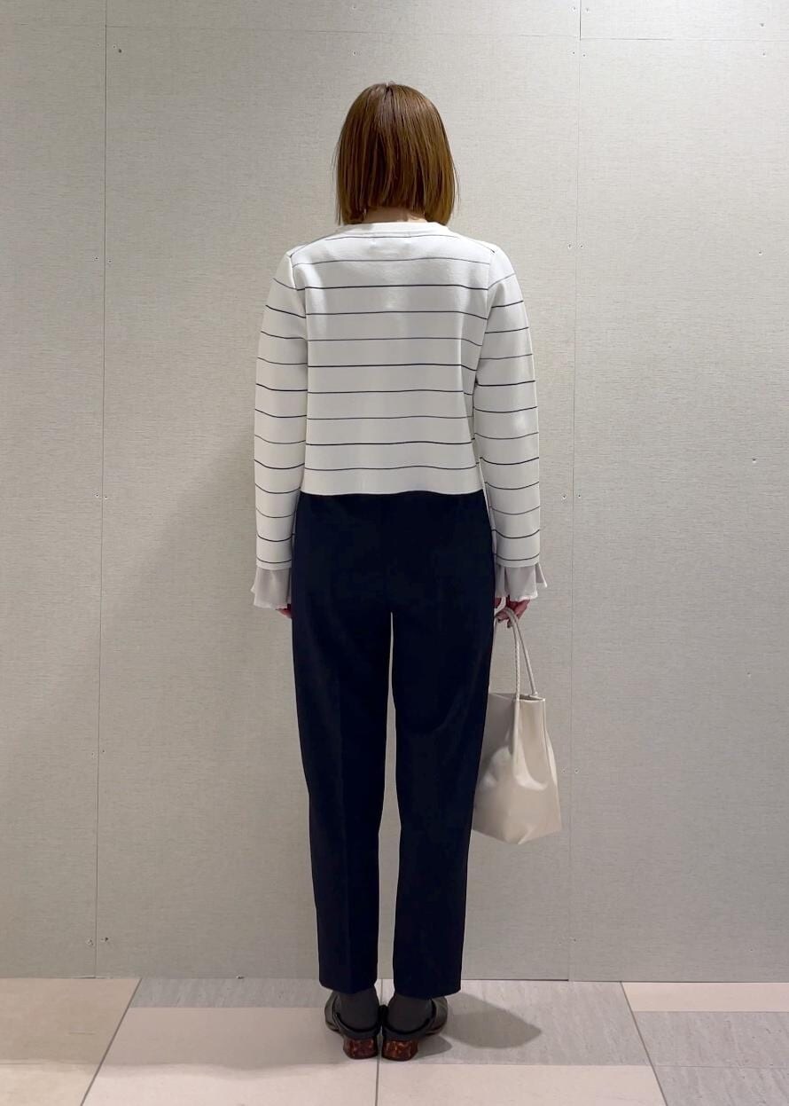 ホワイト系のトートバッグ、グレー系のニット/セーター、ホワイト系のカーディガン/ボレロを着用したレディースの冬コーディネートの3枚目の写真