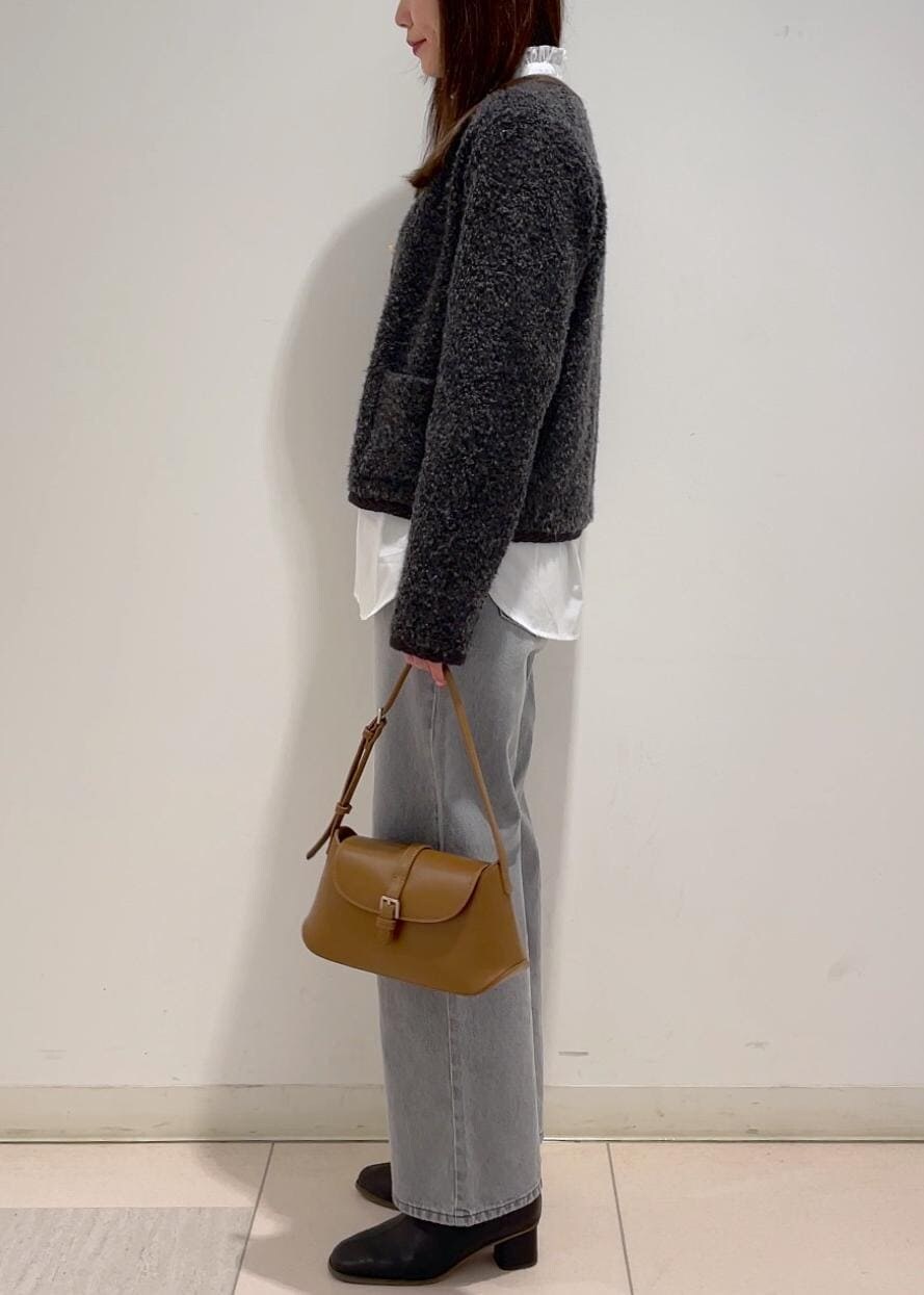 ブラウン系のショルダーバッグ、ブラック系のブーツ、グレー系のブルゾンを着用したレディースの冬コーディネートの2枚目の写真