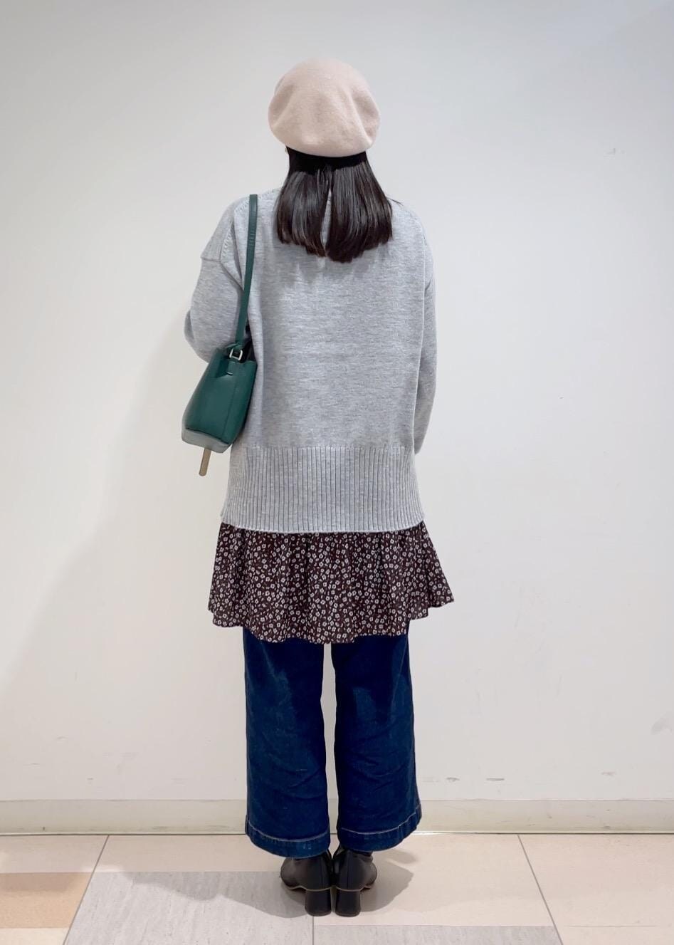ブルー系のデニムパンツ、グレー系のニット/セーター、ブラウン系のワンピースを着用したレディースの冬コーディネートの3枚目の写真