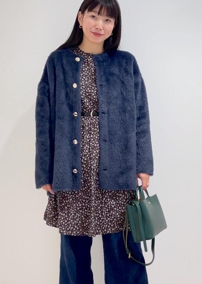 ブルー系のデニムパンツ、ブラウン系のワンピース、ブラック系のブーツを着用したレディースの冬コーディネートの4枚目の写真