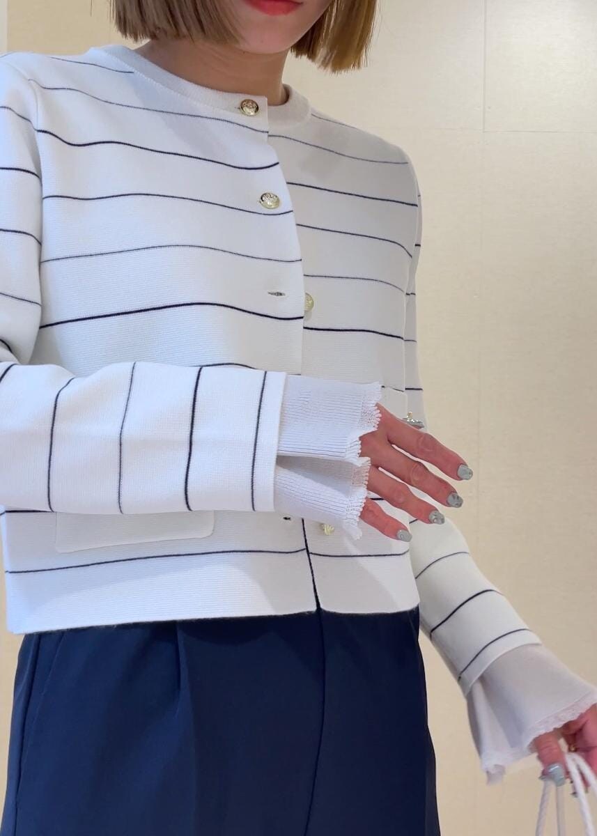 ホワイト系のトートバッグ、グレー系のニット/セーター、ホワイト系のカーディガン/ボレロを着用したレディースの冬コーディネートの7枚目の写真