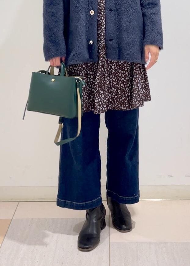 ブルー系のデニムパンツ、ブラウン系のワンピース、ブラック系のブーツを着用したレディースの冬コーディネートの5枚目の写真