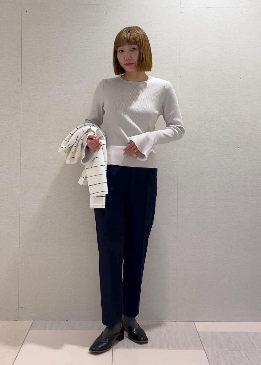 ホワイト系のトートバッグ、グレー系のニット/セーター、ホワイト系のカーディガン/ボレロを着用したレディースの冬コーディネートの4枚目の写真