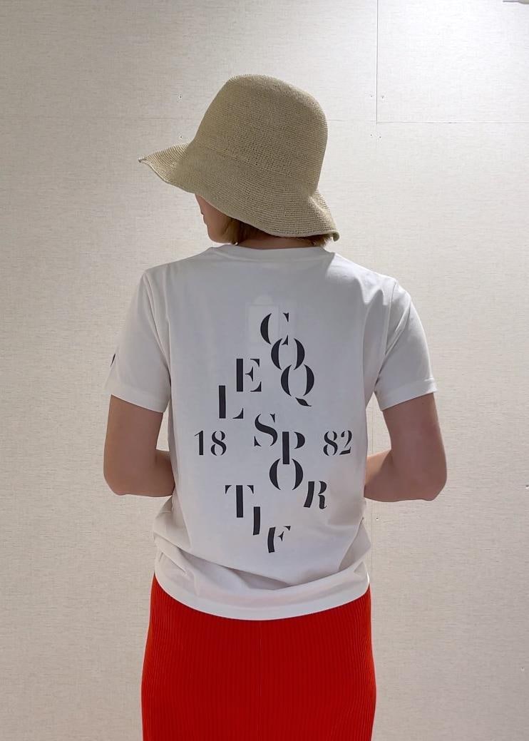 オレンジ系のスカート、ブラック系のトートバッグ、ブラック系のパンプスを着用したレディースの春コーディネートの3枚目の写真