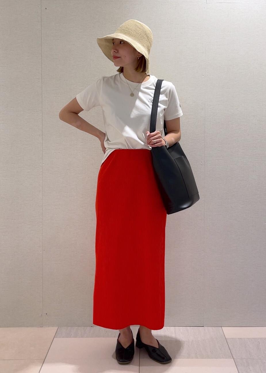 オレンジ系のスカート、ブラック系のトートバッグ、ブラック系のパンプスを着用したレディースの春コーディネートの6枚目の写真