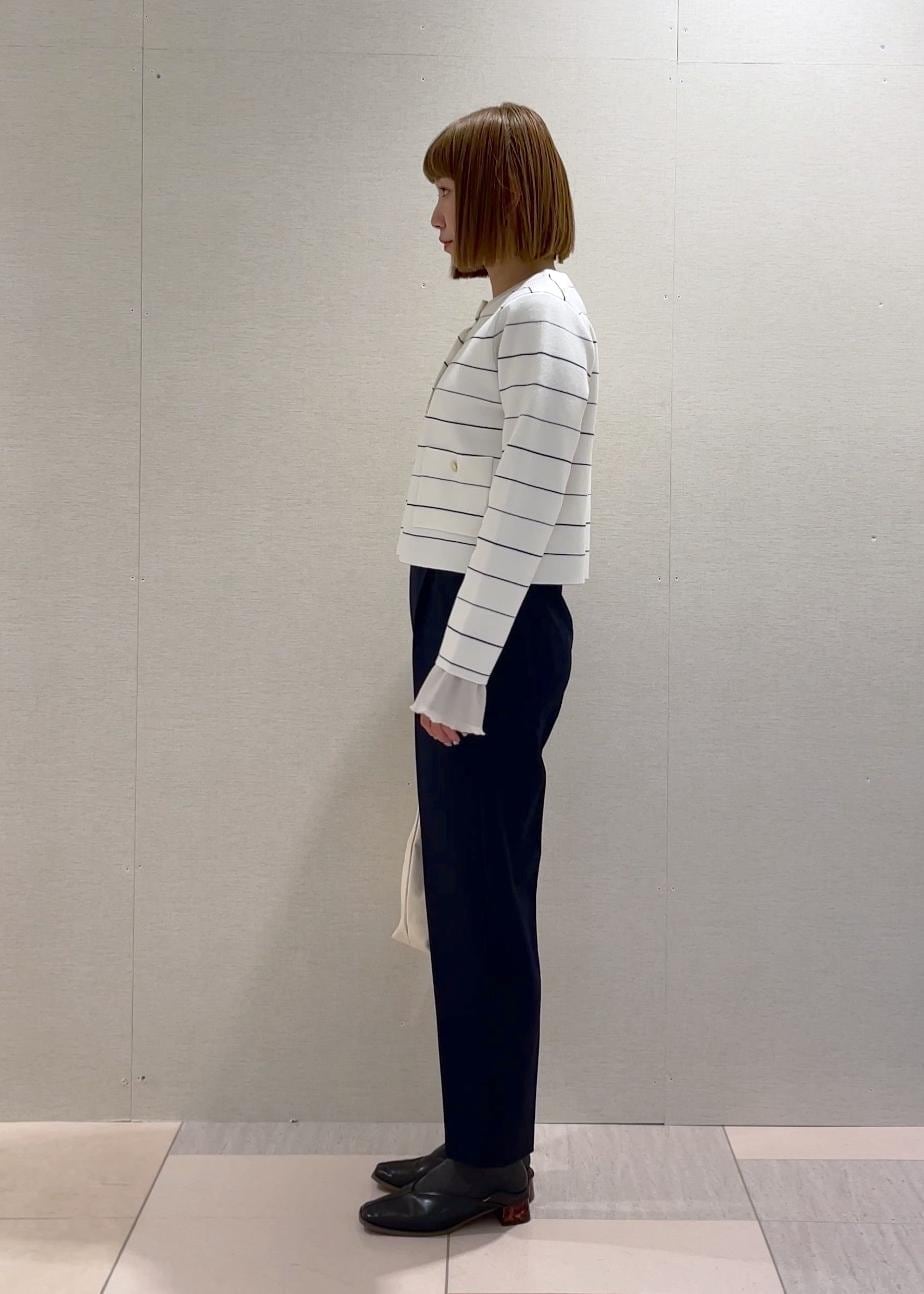 ホワイト系のトートバッグ、グレー系のニット/セーター、ホワイト系のカーディガン/ボレロを着用したレディースの冬コーディネートの2枚目の写真