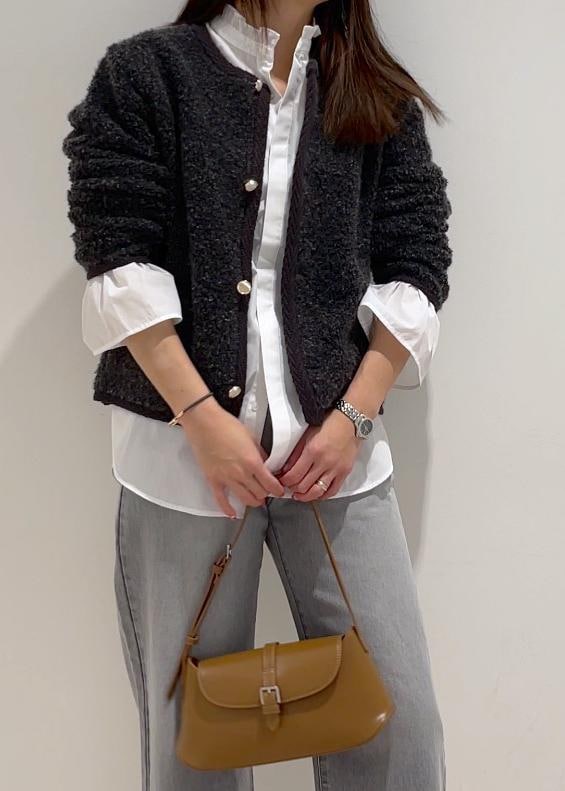 ブラウン系のショルダーバッグ、ブラック系のブーツ、グレー系のブルゾンを着用したレディースの冬コーディネートの3枚目の写真