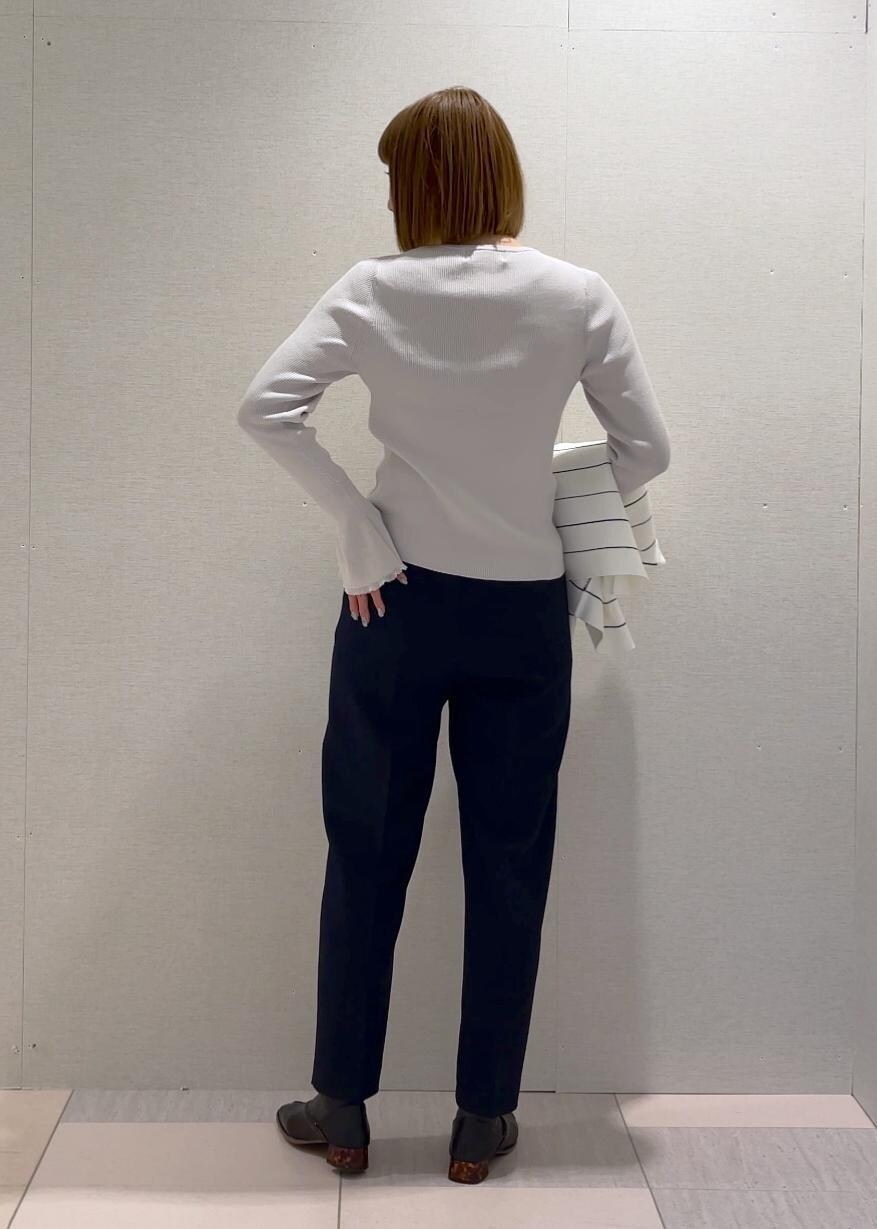 ホワイト系のトートバッグ、グレー系のニット/セーター、ホワイト系のカーディガン/ボレロを着用したレディースの冬コーディネートの5枚目の写真