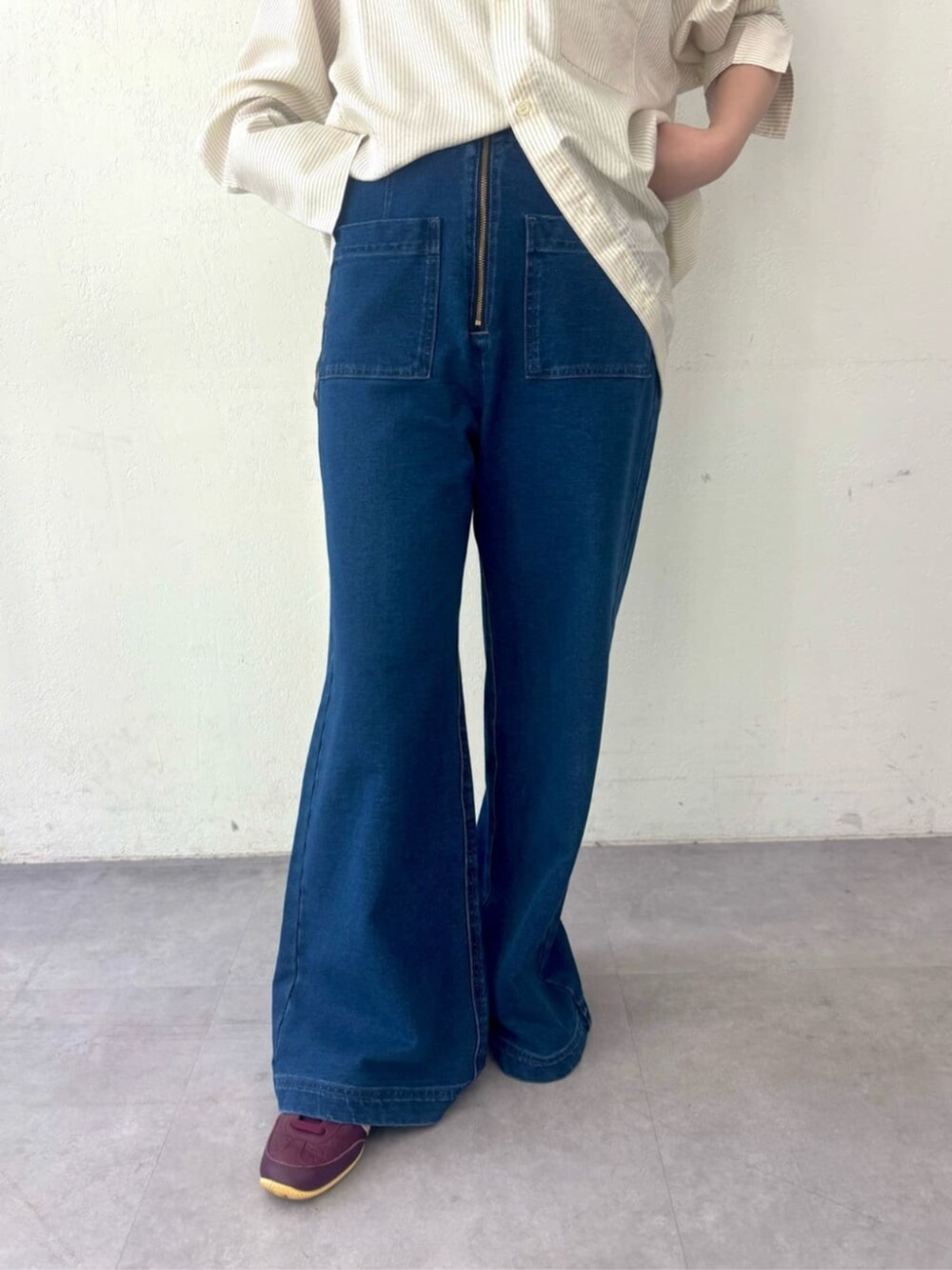 ブルー系のデニムパンツ、ホワイト系のシャツ/ブラウス、レッド系のスニーカーを着用したレディースの秋コーディネートの4枚目の写真