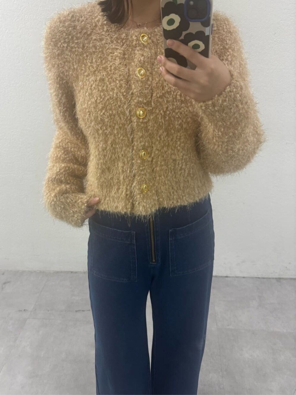 ブルー系のデニムパンツ、ベージュ系のカーディガン/ボレロ、ブラック系のパンプスを着用したレディースの秋コーディネートの2枚目の写真