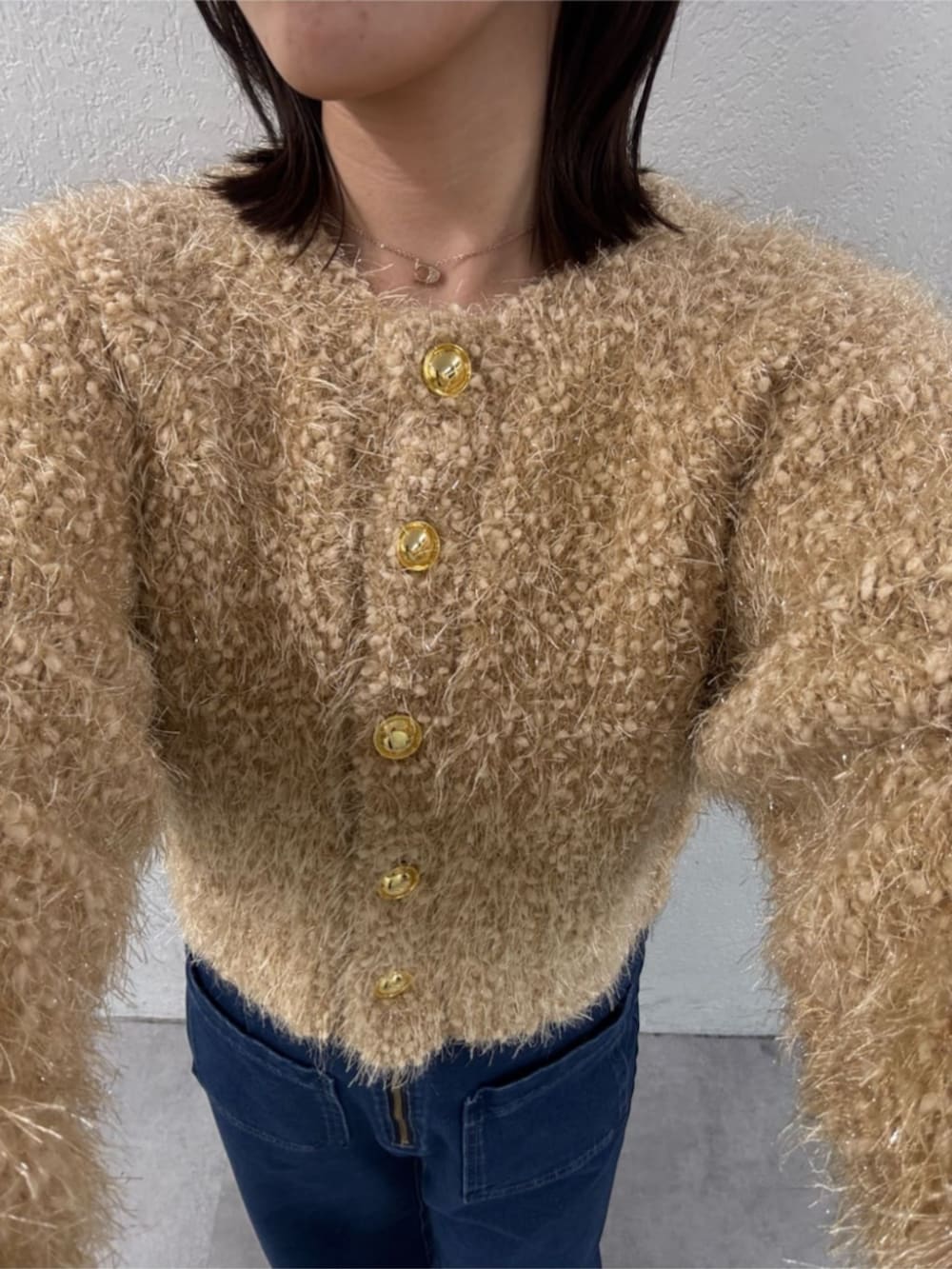 ブルー系のデニムパンツ、ベージュ系のカーディガン/ボレロ、ブラック系のパンプスを着用したレディースの秋コーディネートの3枚目の写真