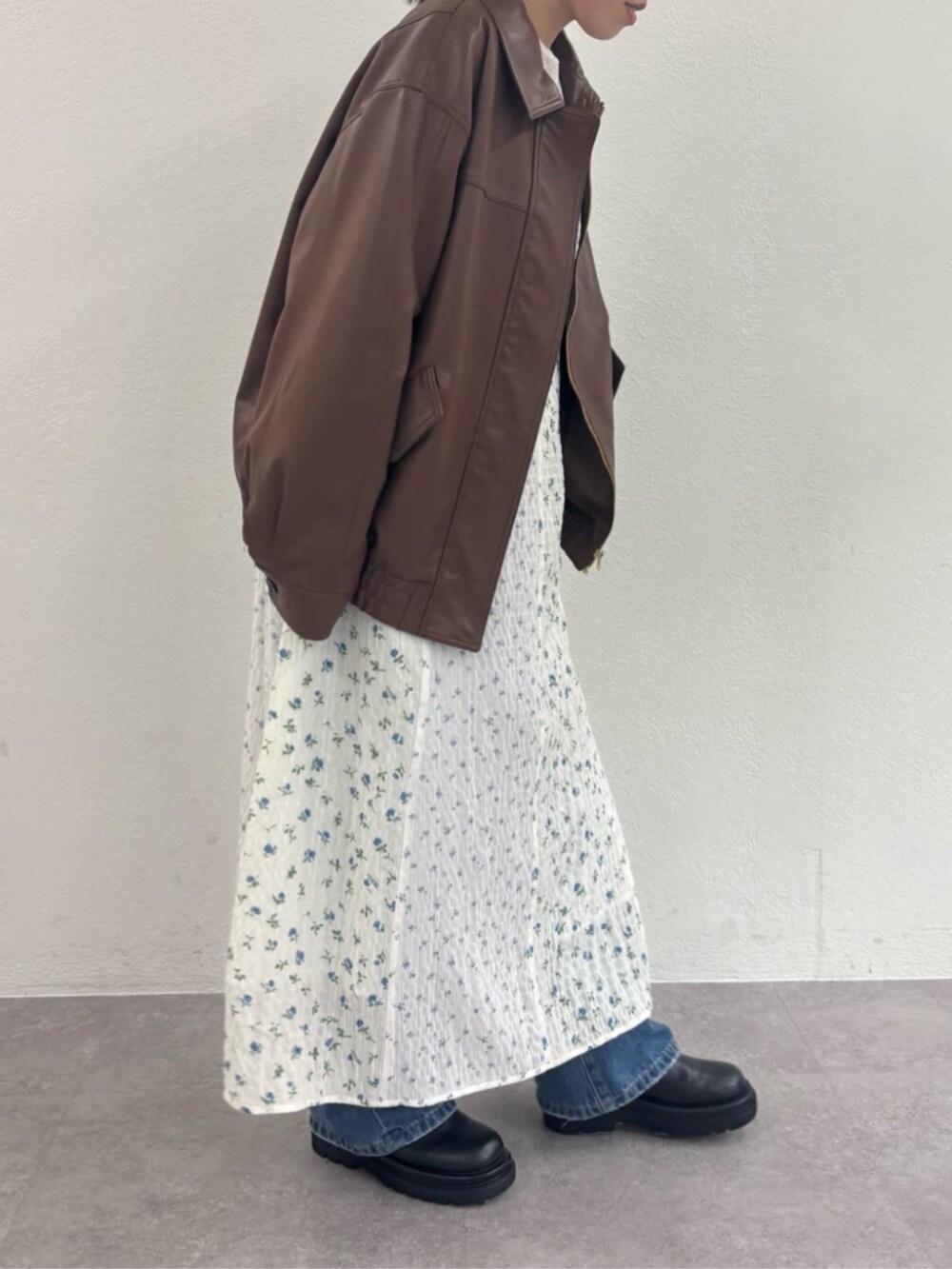 ブラック系のブーツ、ブルー系のデニムパンツ、ブラウン系のブルゾンを着用したレディースの冬コーディネートの3枚目の写真