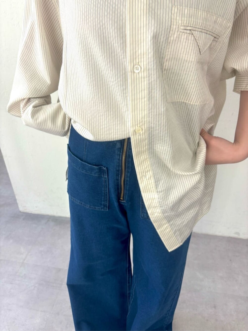 ブルー系のデニムパンツ、ホワイト系のシャツ/ブラウス、レッド系のスニーカーを着用したレディースの秋コーディネートの5枚目の写真