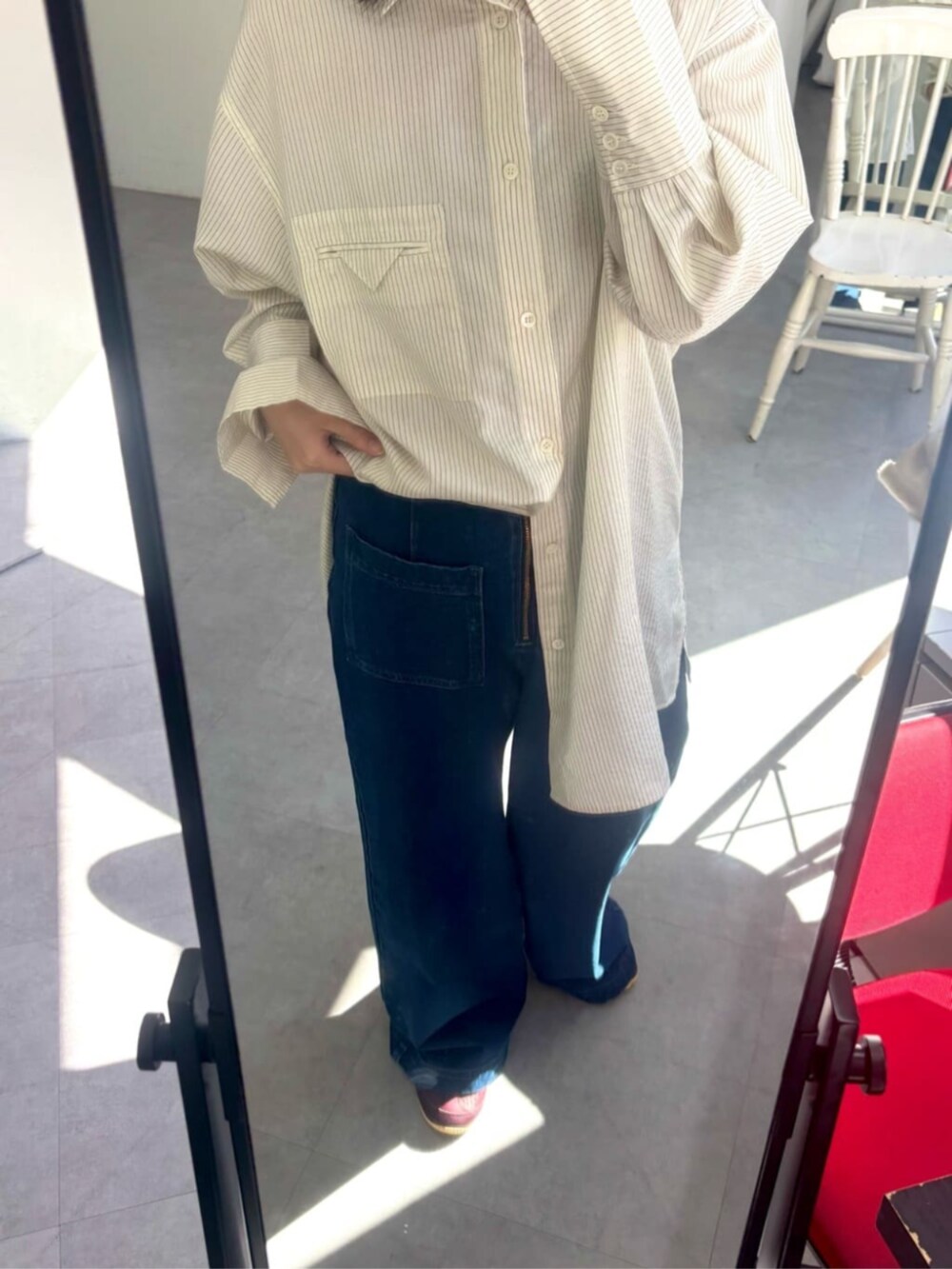 ブルー系のデニムパンツ、ホワイト系のシャツ/ブラウス、レッド系のスニーカーを着用したレディースの秋コーディネートの3枚目の写真