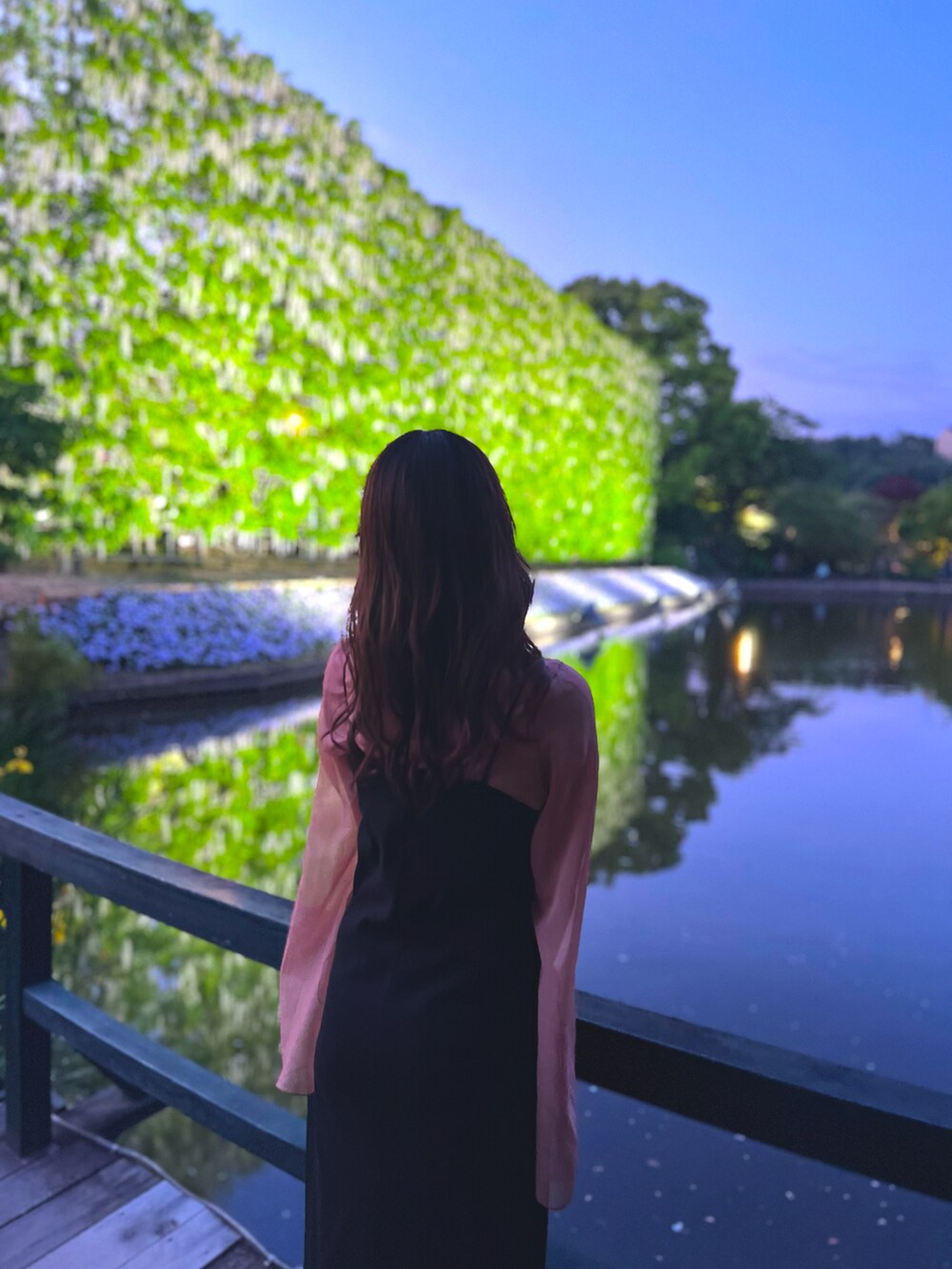 オレンジ系のトップス、ブラック系のワンピースを着用したレディースの秋コーディネートの2枚目の写真