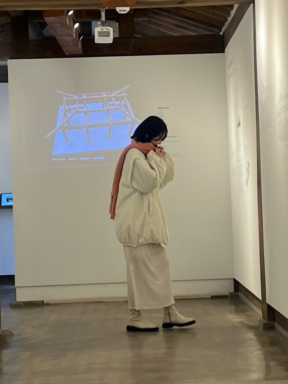 ホワイト系のブルゾン、ホワイト系のスカート、ホワイト系のブーツを着用したレディースの春コーディネートの3枚目の写真