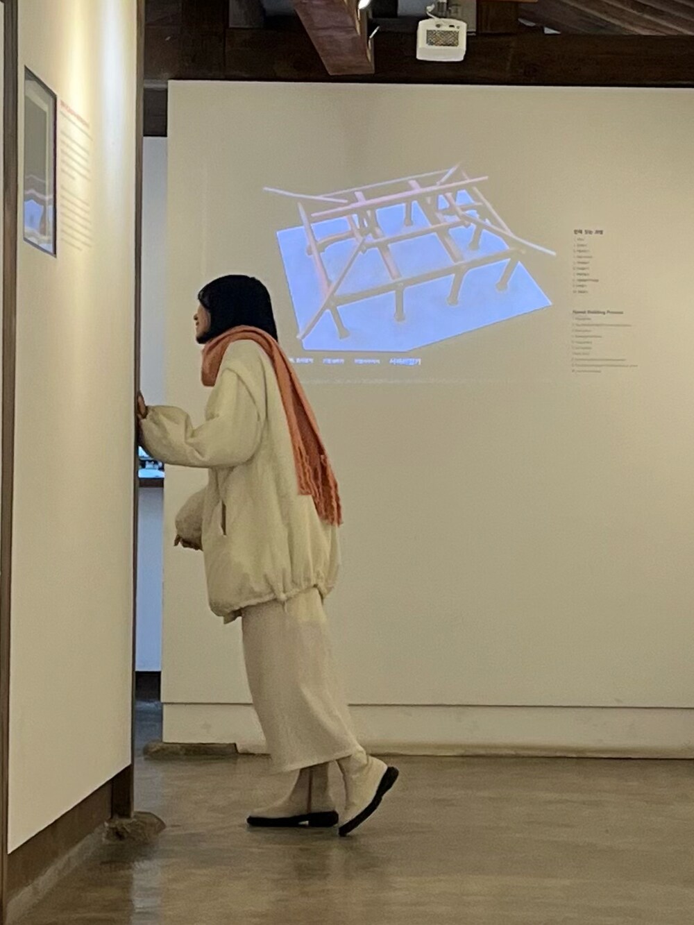 ホワイト系のブルゾン、ホワイト系のスカート、ホワイト系のブーツを着用したレディースの春コーディネートの2枚目の写真