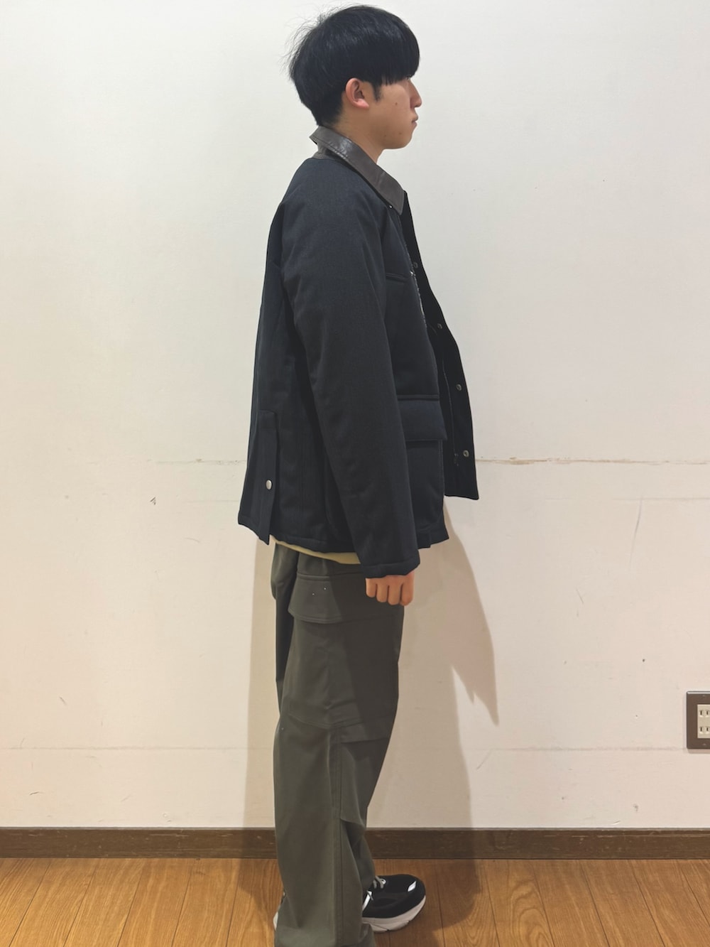 グリーン系のその他パンツ、イエロー系のTシャツ/カットソー、ブラック系のダウンジャケット/コートを着用したメンズの冬コーディネートの2枚目の写真