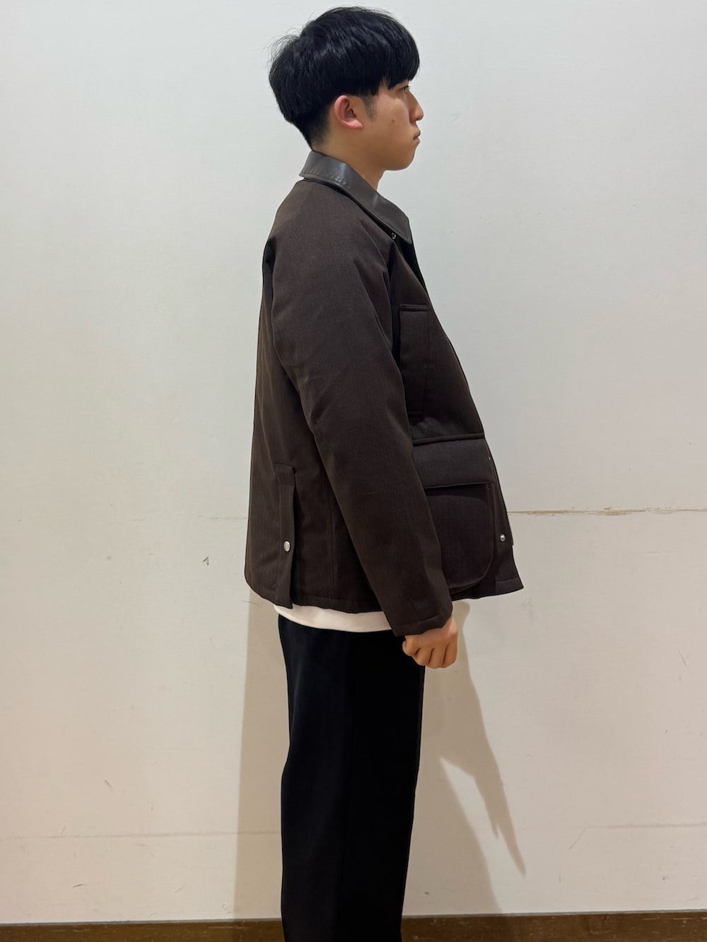 ブラック系のその他パンツ、ブラウン系のダウンジャケット/コート、その他のスウェットを着用したメンズの冬コーディネートの2枚目の写真