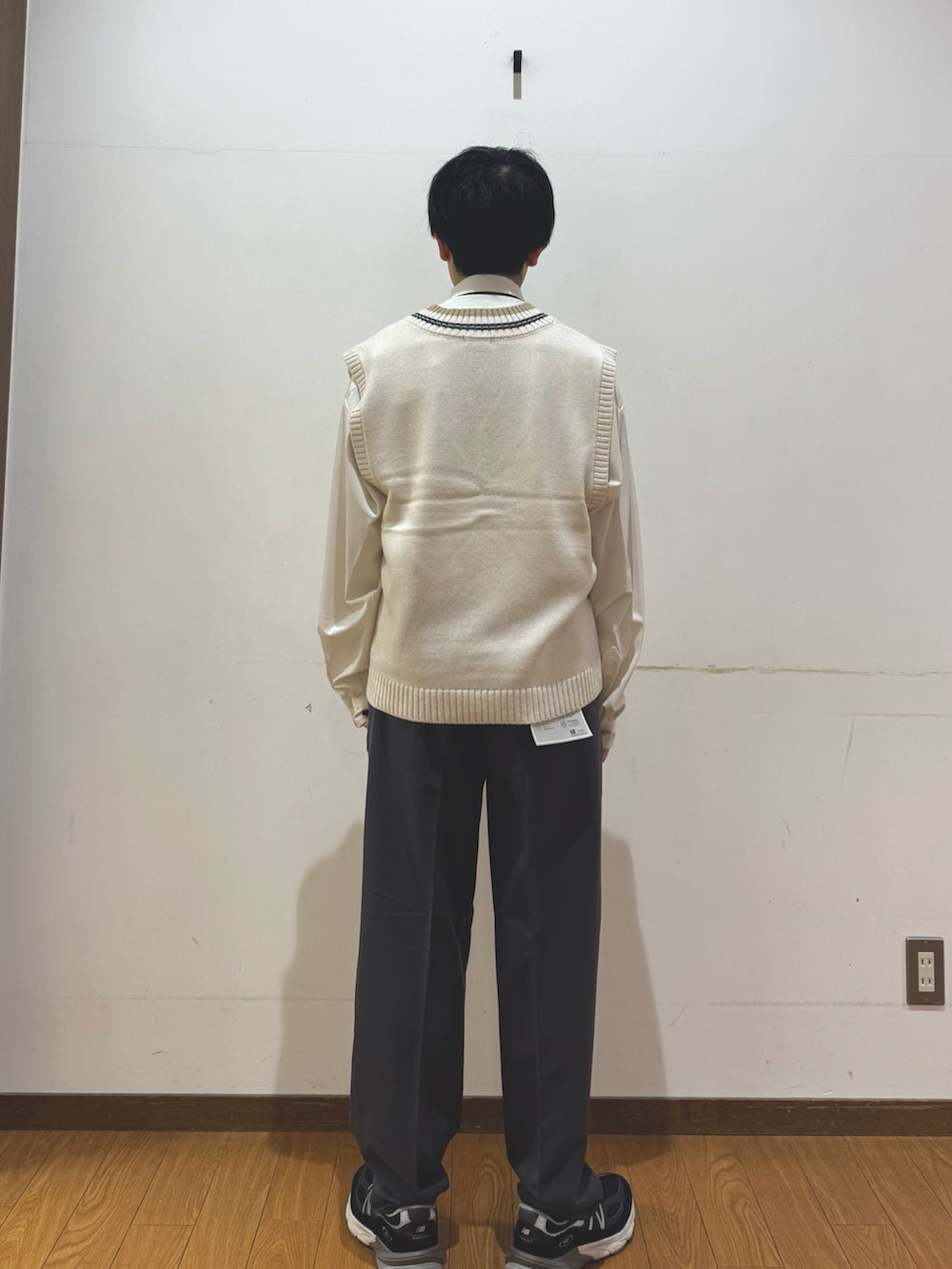 ホワイト系のベスト、グレー系のその他パンツを着用したメンズの秋コーディネートの3枚目の写真