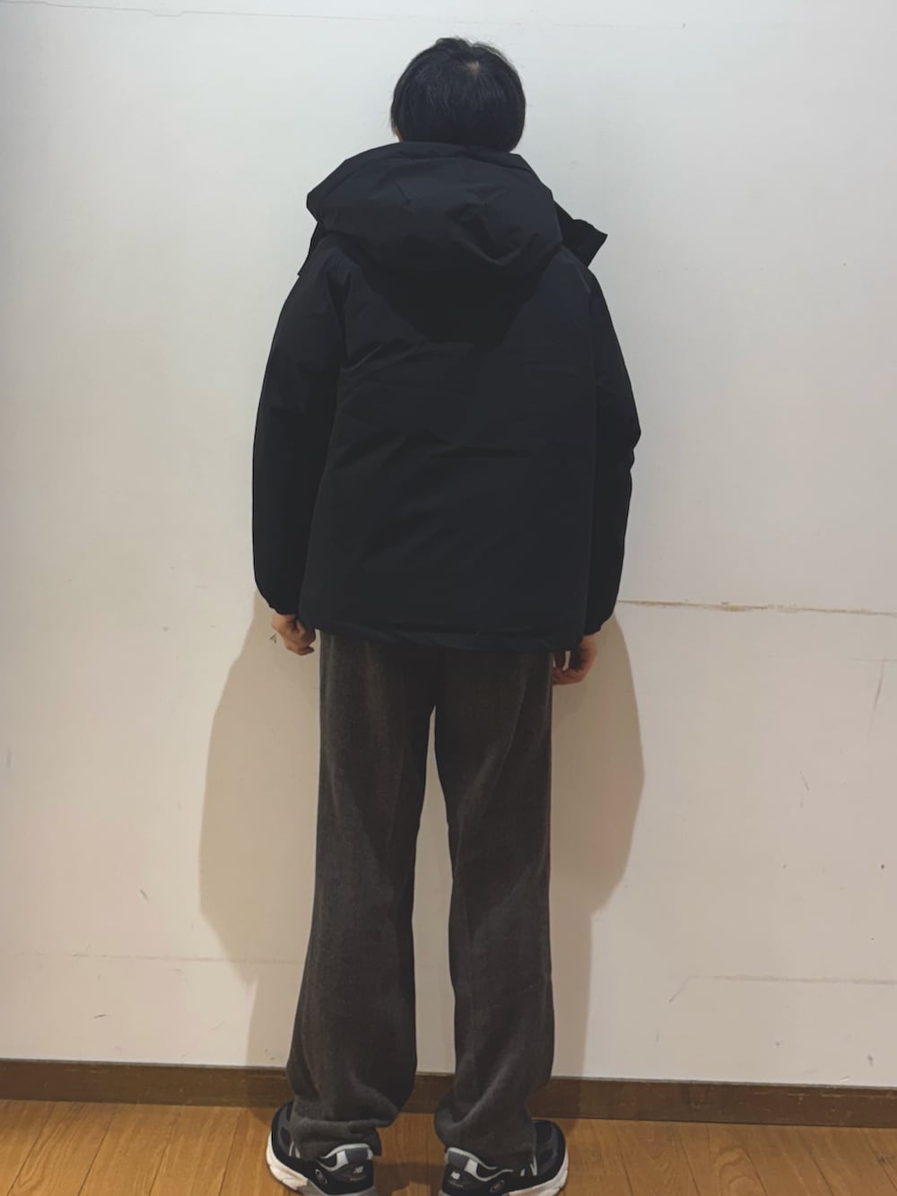 ブラウン系のその他パンツ、ブラック系のダウンジャケット/コート、レッド系のニット/セーターを着用したメンズの秋コーディネートの3枚目の写真