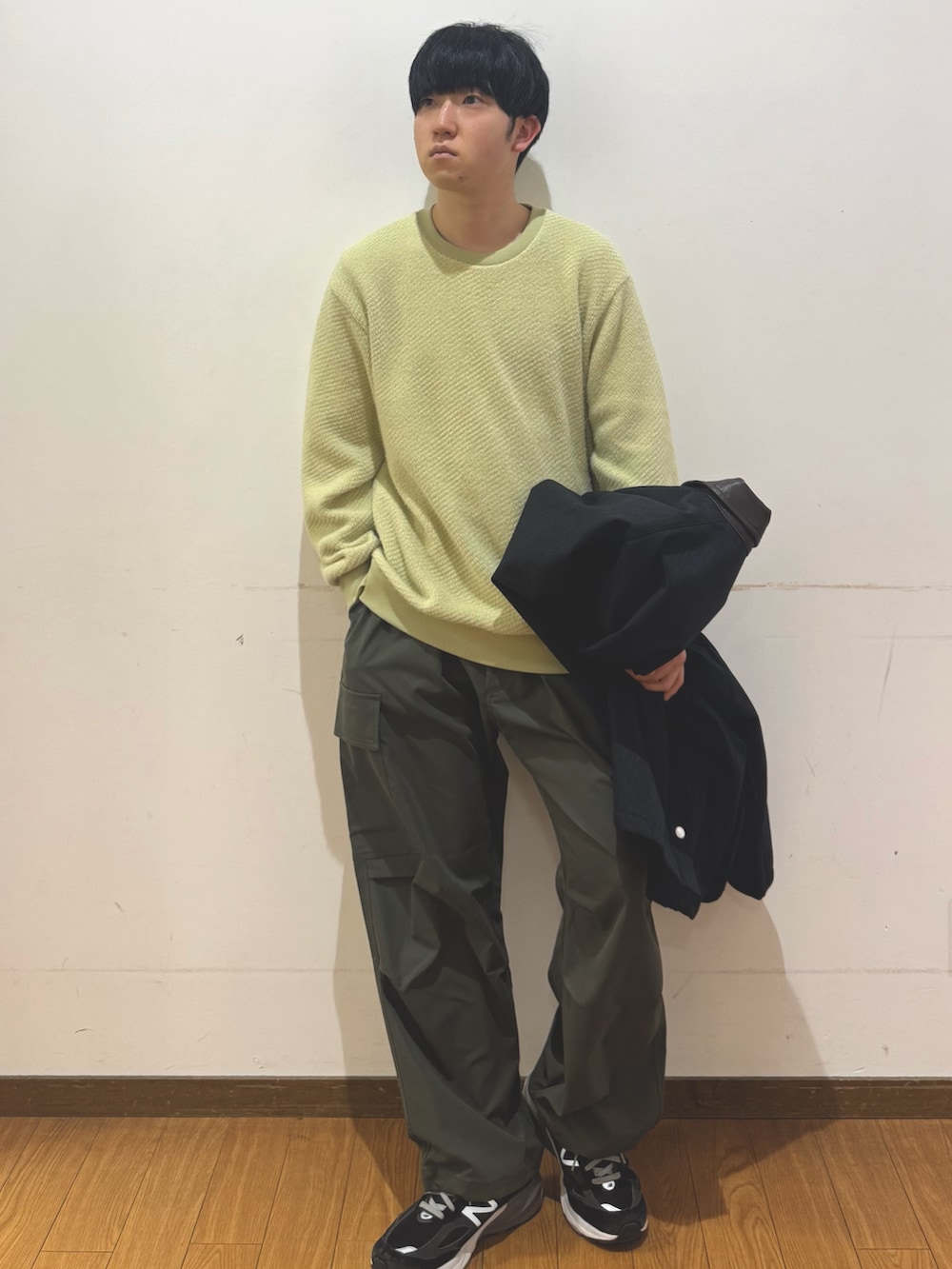 グリーン系のその他パンツ、イエロー系のTシャツ/カットソー、ブラック系のダウンジャケット/コートを着用したメンズの冬コーディネートの4枚目の写真