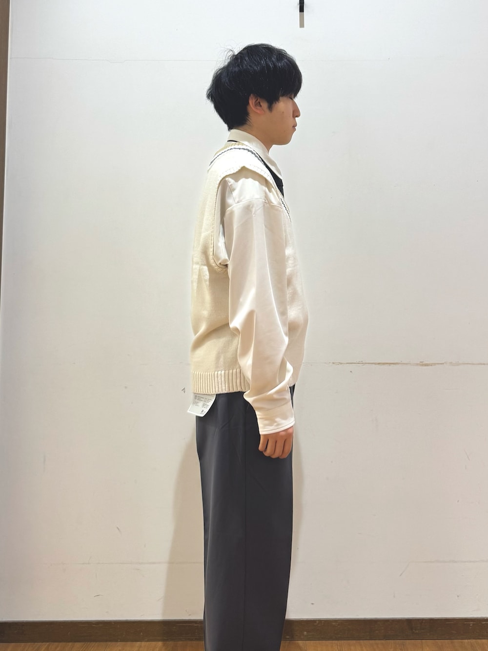 ホワイト系のベスト、グレー系のその他パンツを着用したメンズの秋コーディネートの2枚目の写真